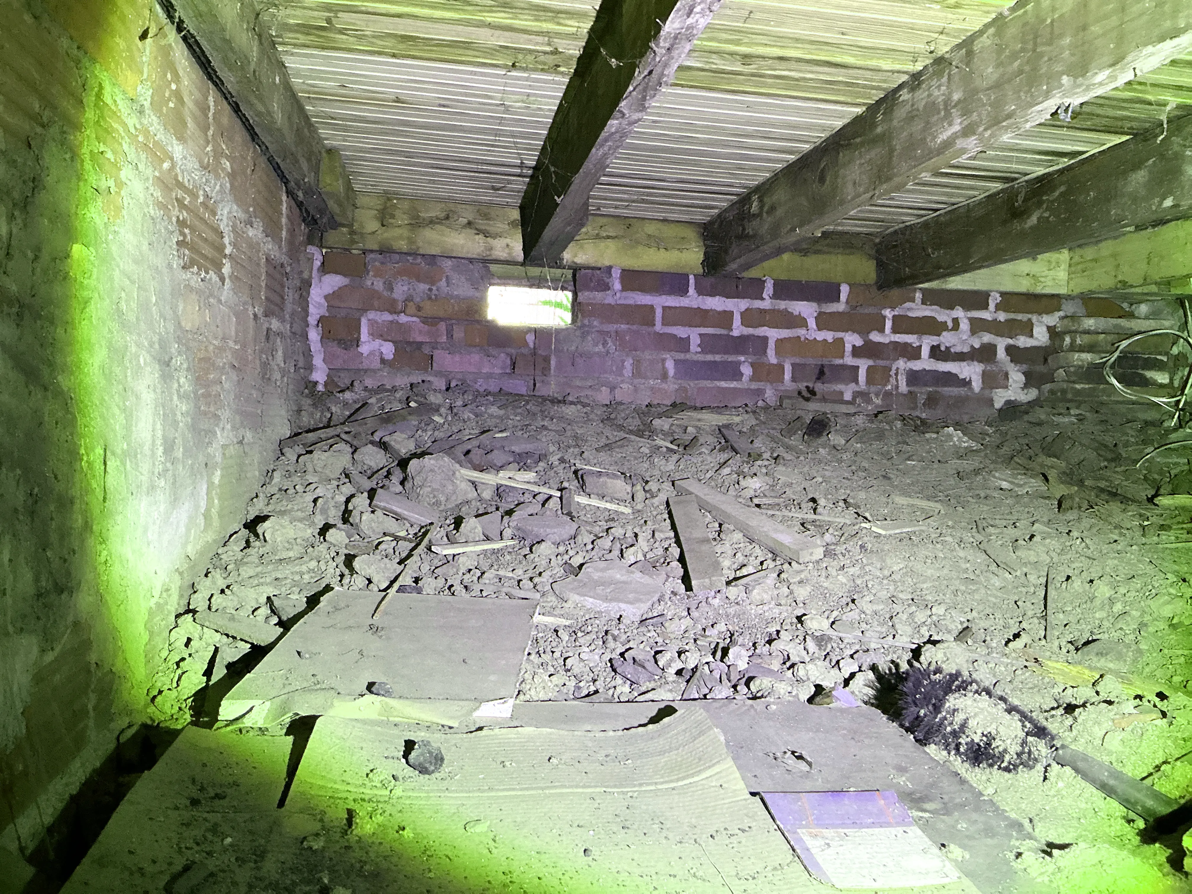 Unfinished crawlspace with dirt floor, debris, exposed joists, and brick foundation wall 2026-09-02