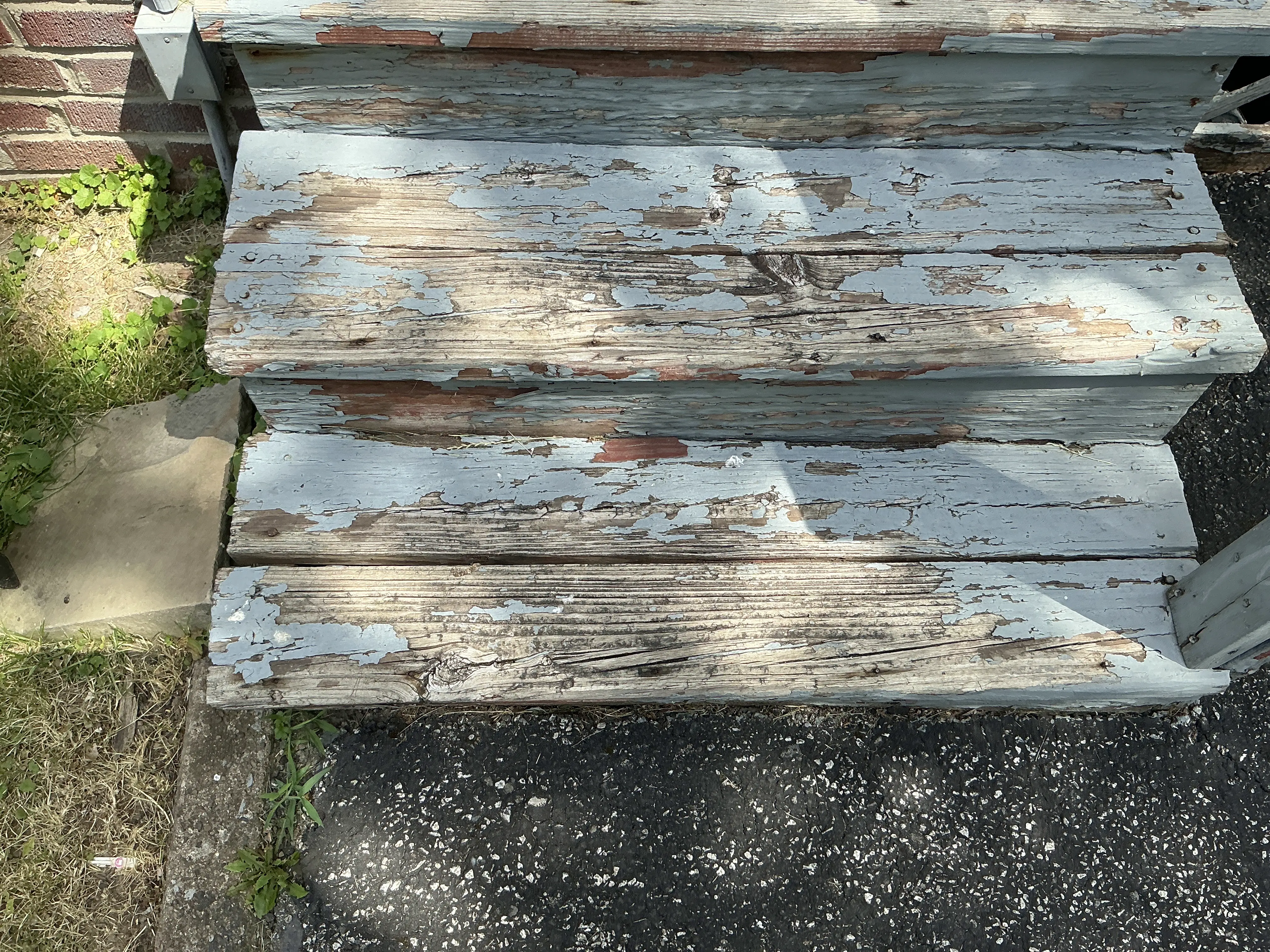 Peeling blue paint on weathered exterior wooden stair treads during a mold testing 2026-07-14