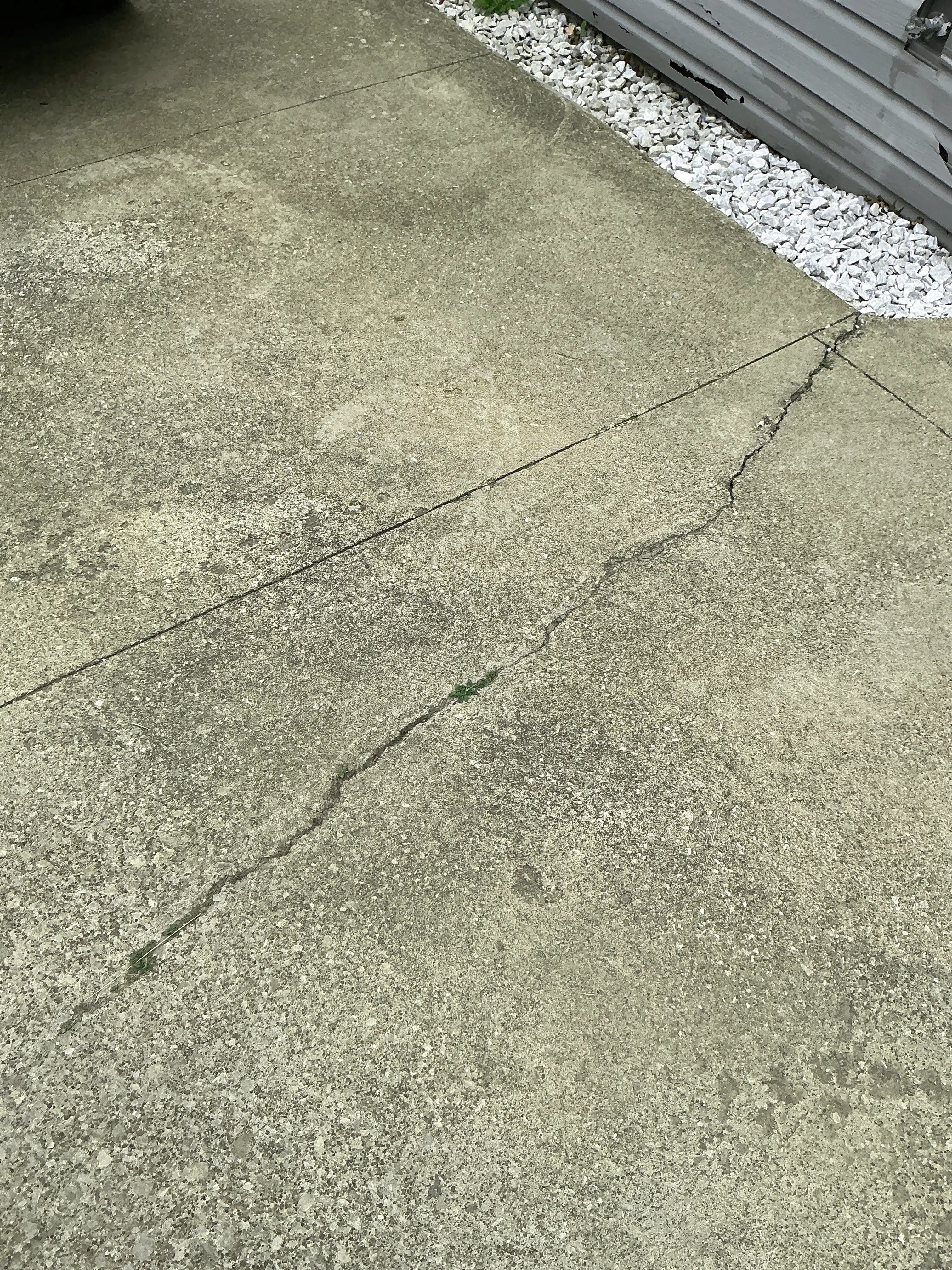Cracked concrete driveway slab requiring maintenance during lead test 2026-07-26