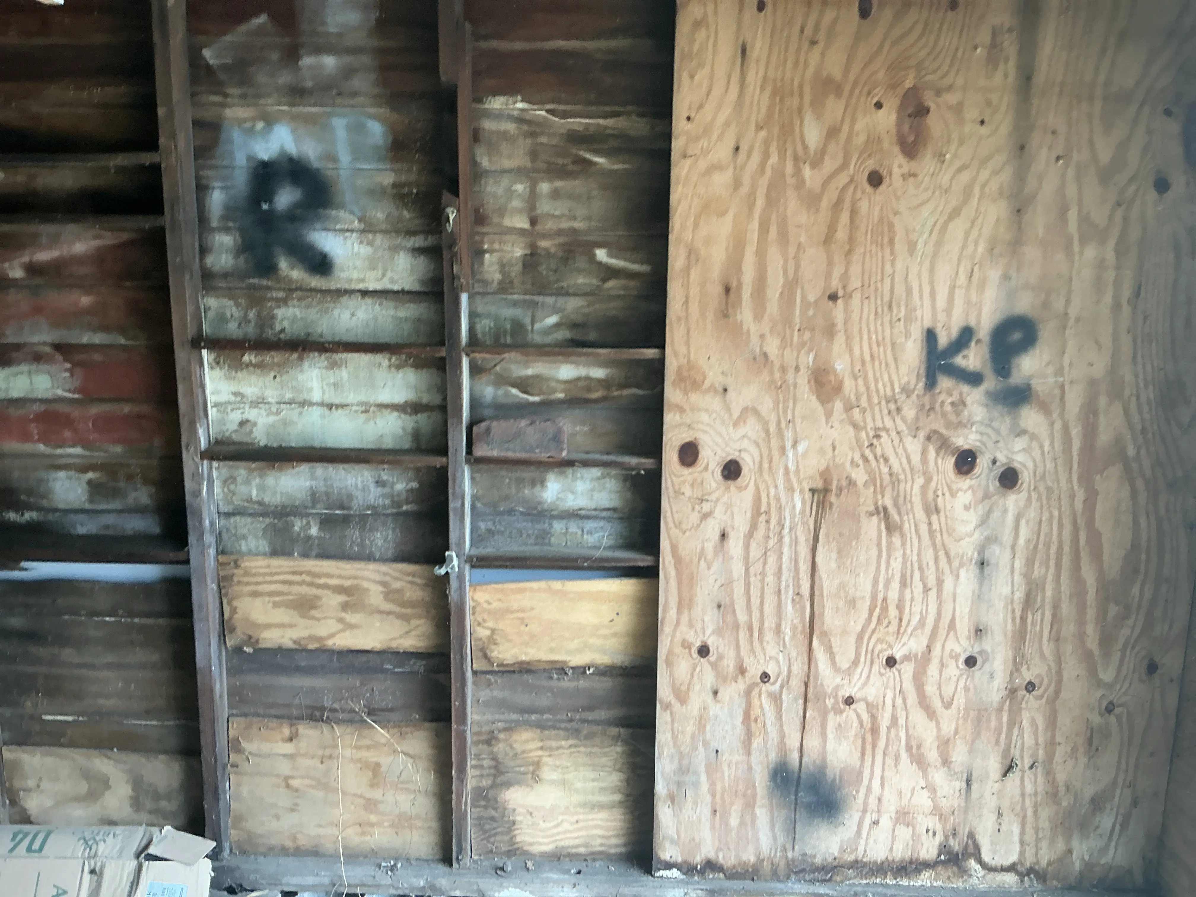 Exposed interior wall framing and plywood paneling during a home inspection 2026-07-21