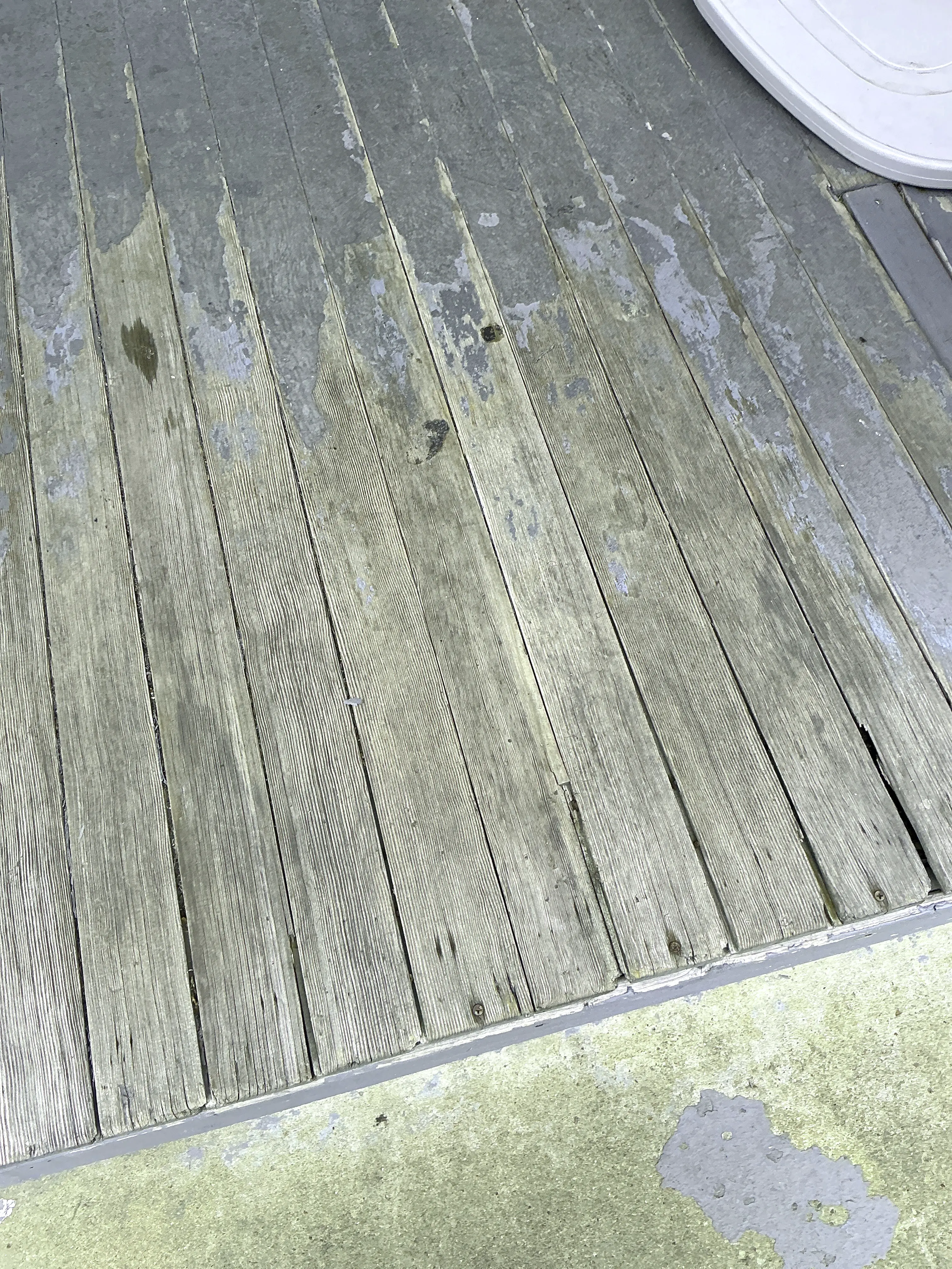 Weathered wood deck boards with peeling paint and surface wear 2026-08-13