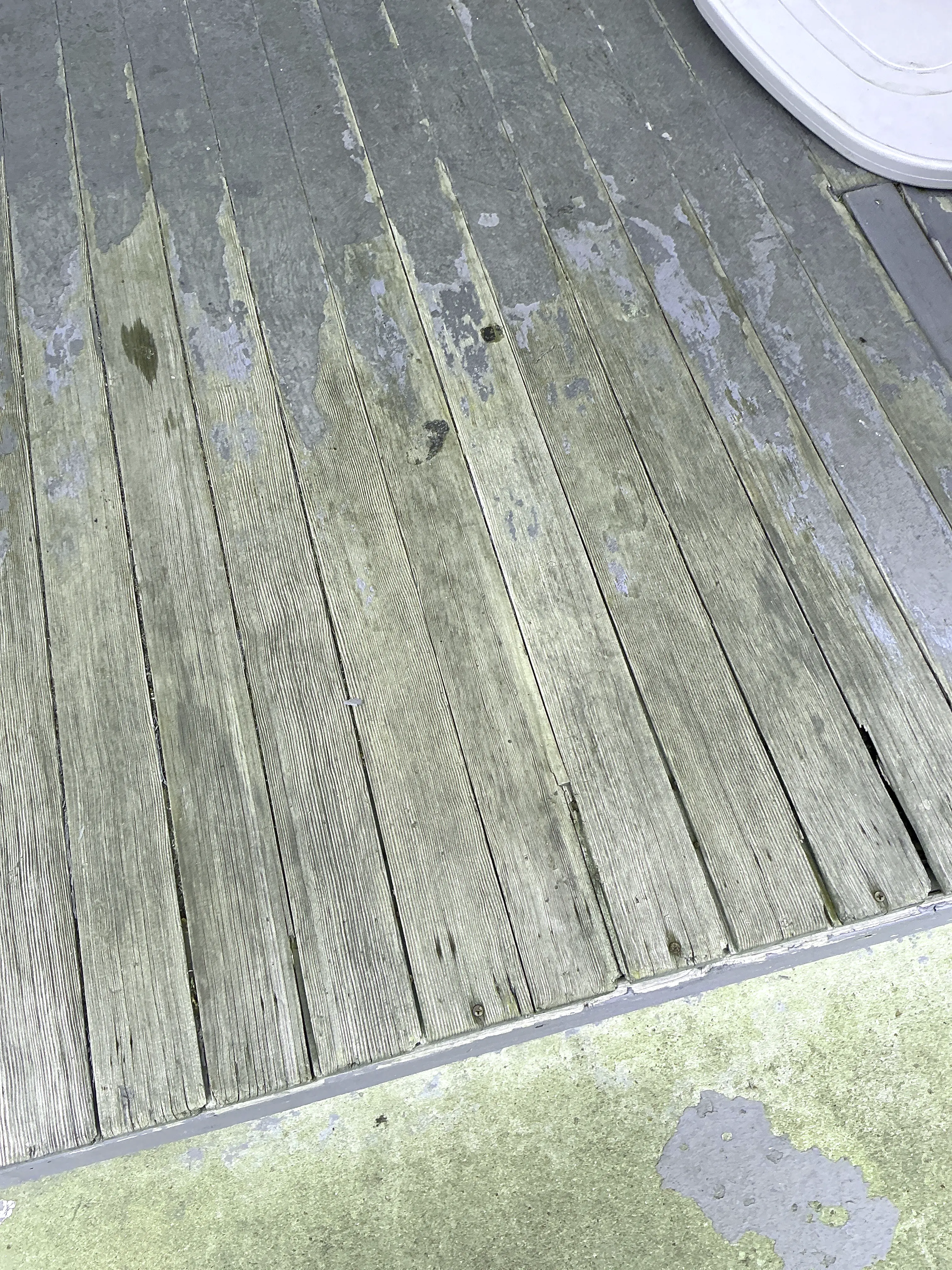 Weathered wood deck boards with peeling paint and surface wear 2026-08-25
