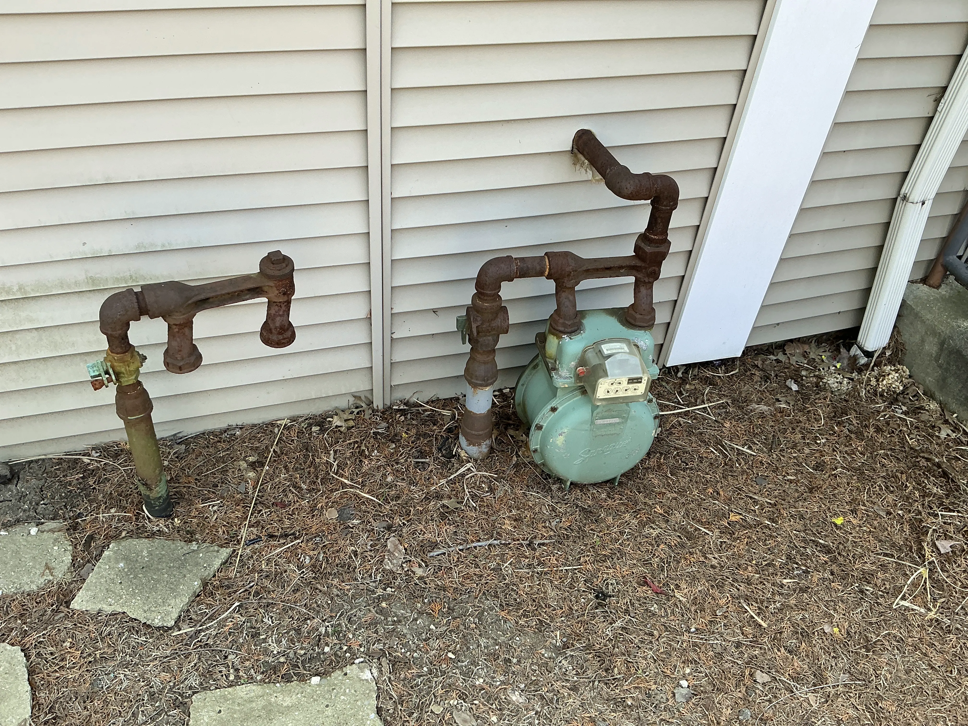 Corroded exterior gas piping and meter installed next to house siding 2026-08-01