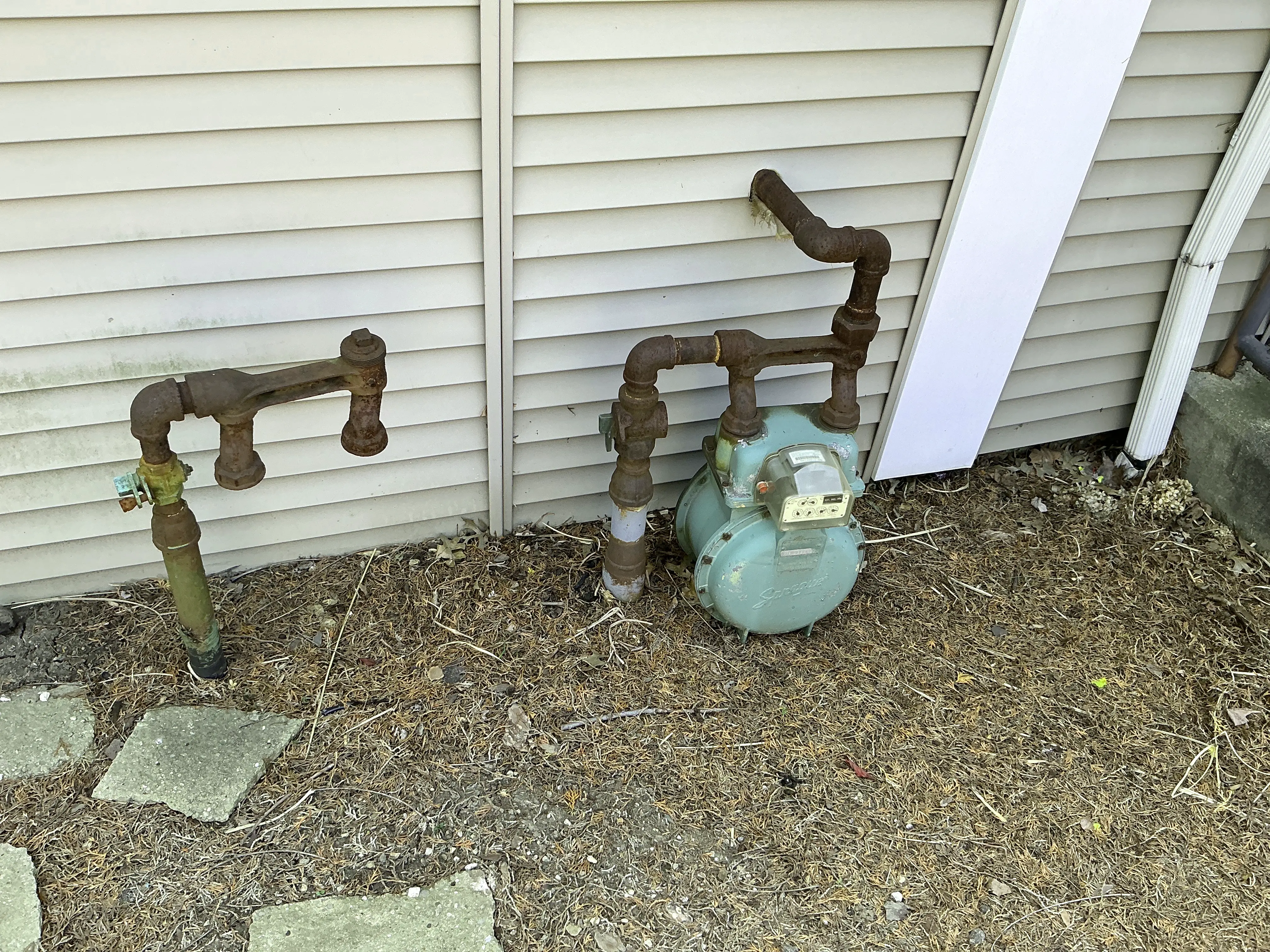 Corroded exterior gas piping and meter installed next to house siding 2026-07-20