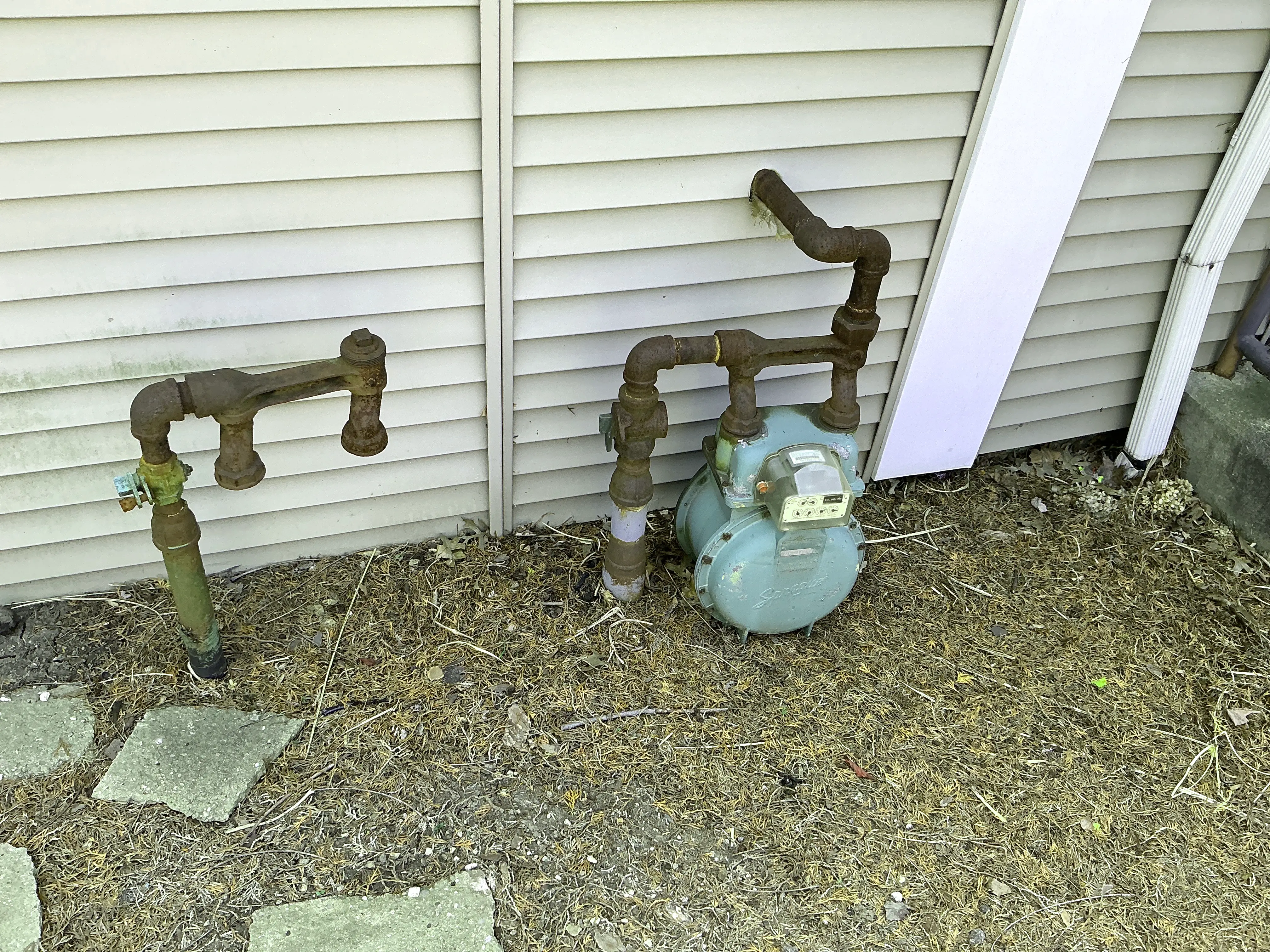 Corroded exterior gas piping and meter installed next to house siding 2026-08-22