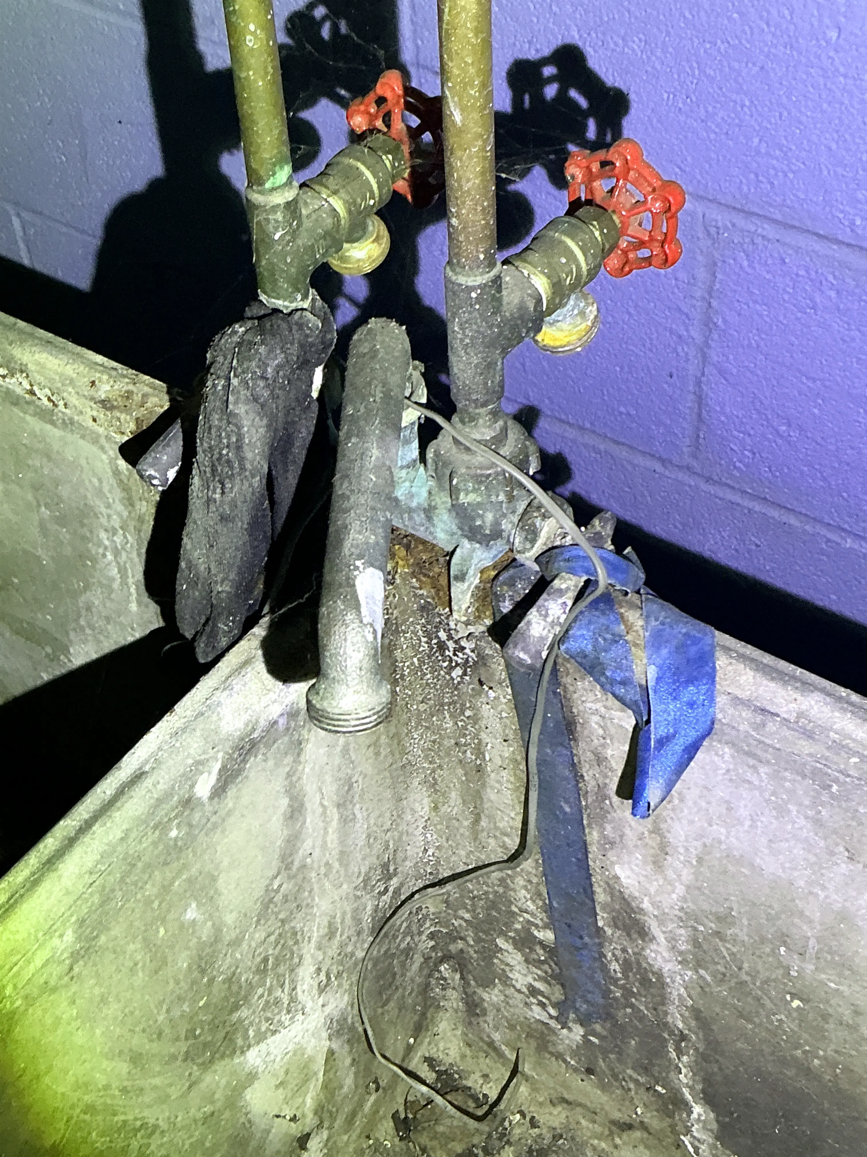 Corroded plumbing pipes and improper grounding wire under utility sink 2026-09-02