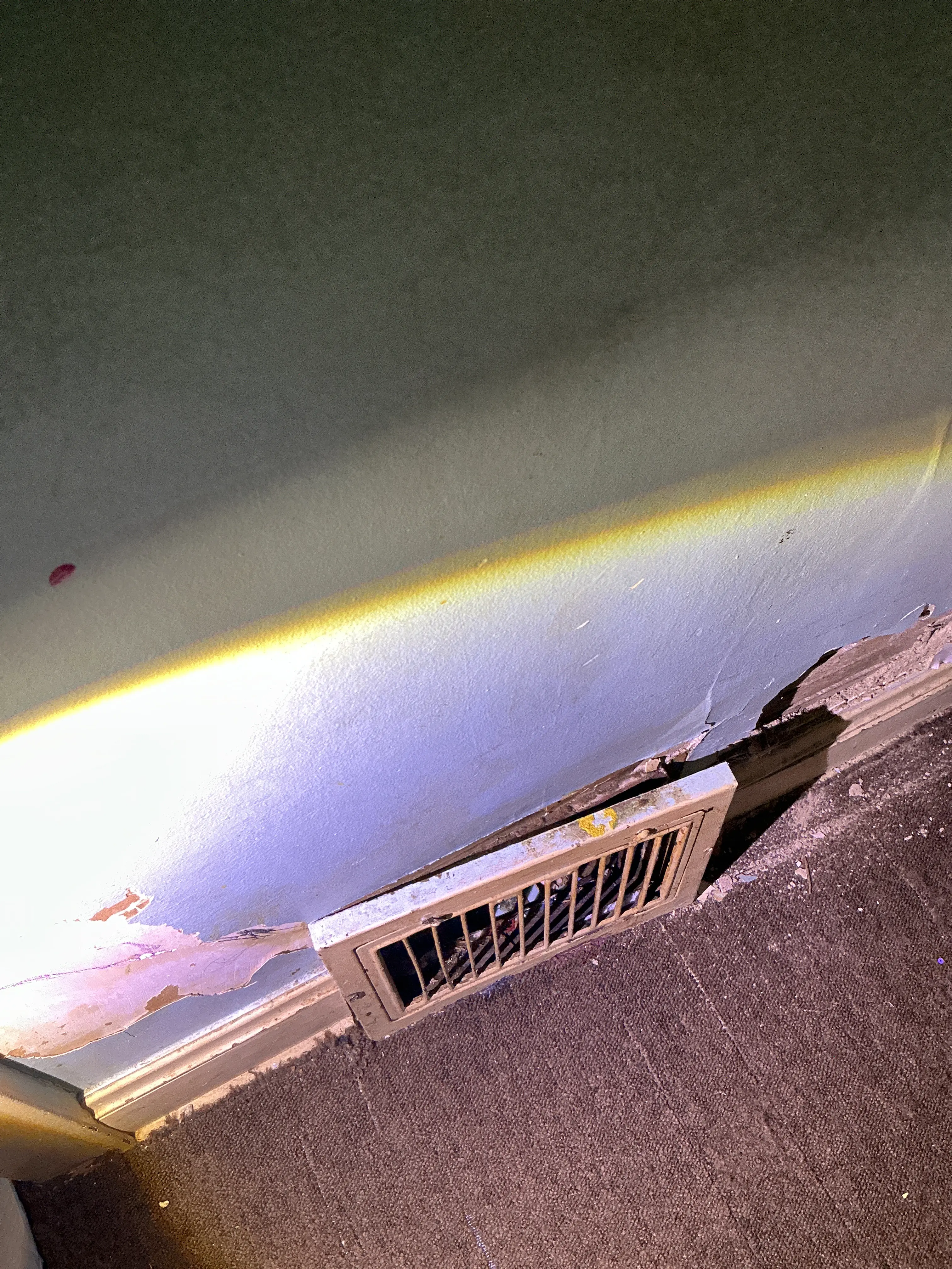 Peeling paint and drywall damage near floor vent register during lead inspection 2026-07-17