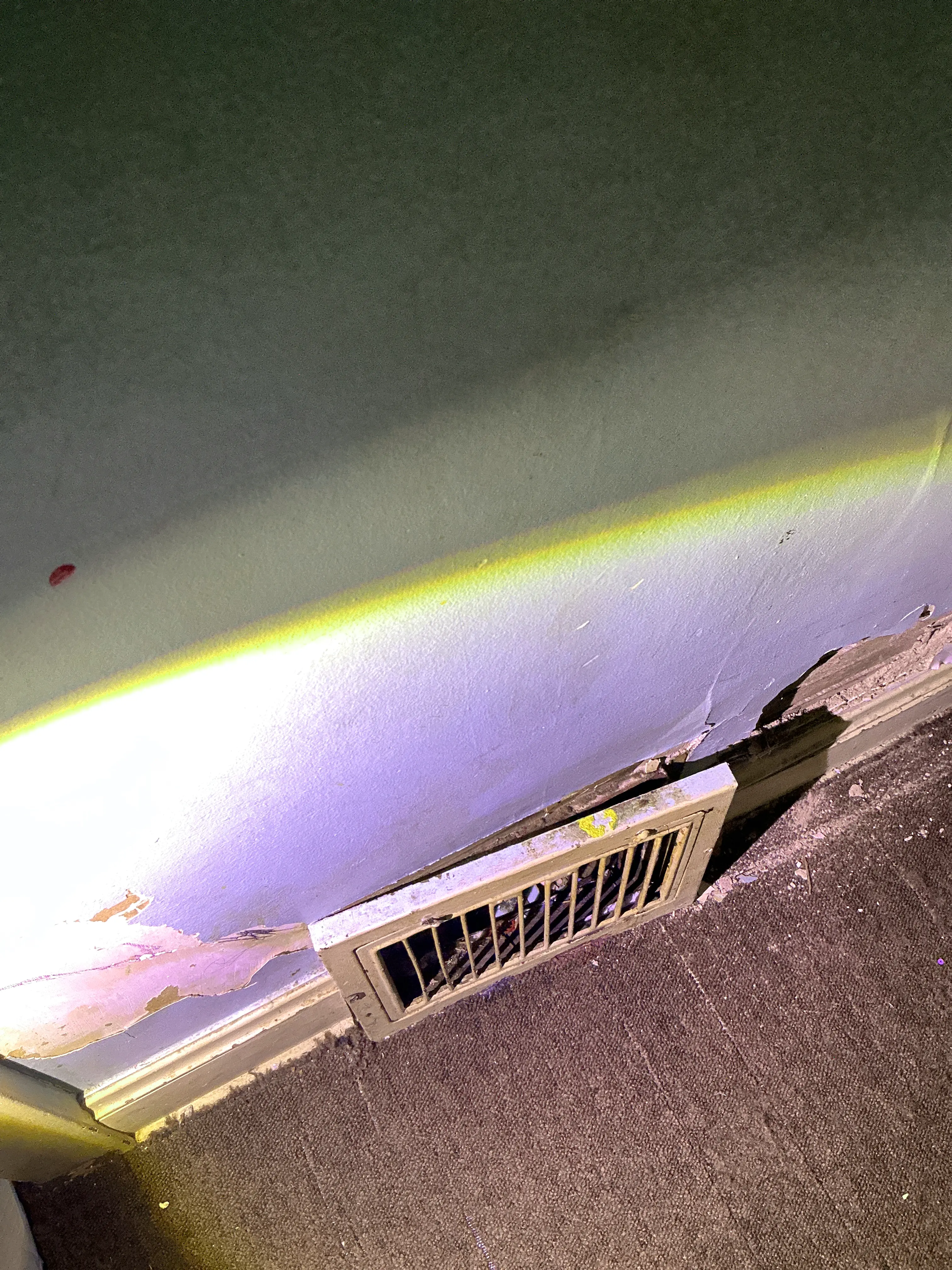 Peeling paint and drywall damage near floor vent register during mold inspection 2026-07-29