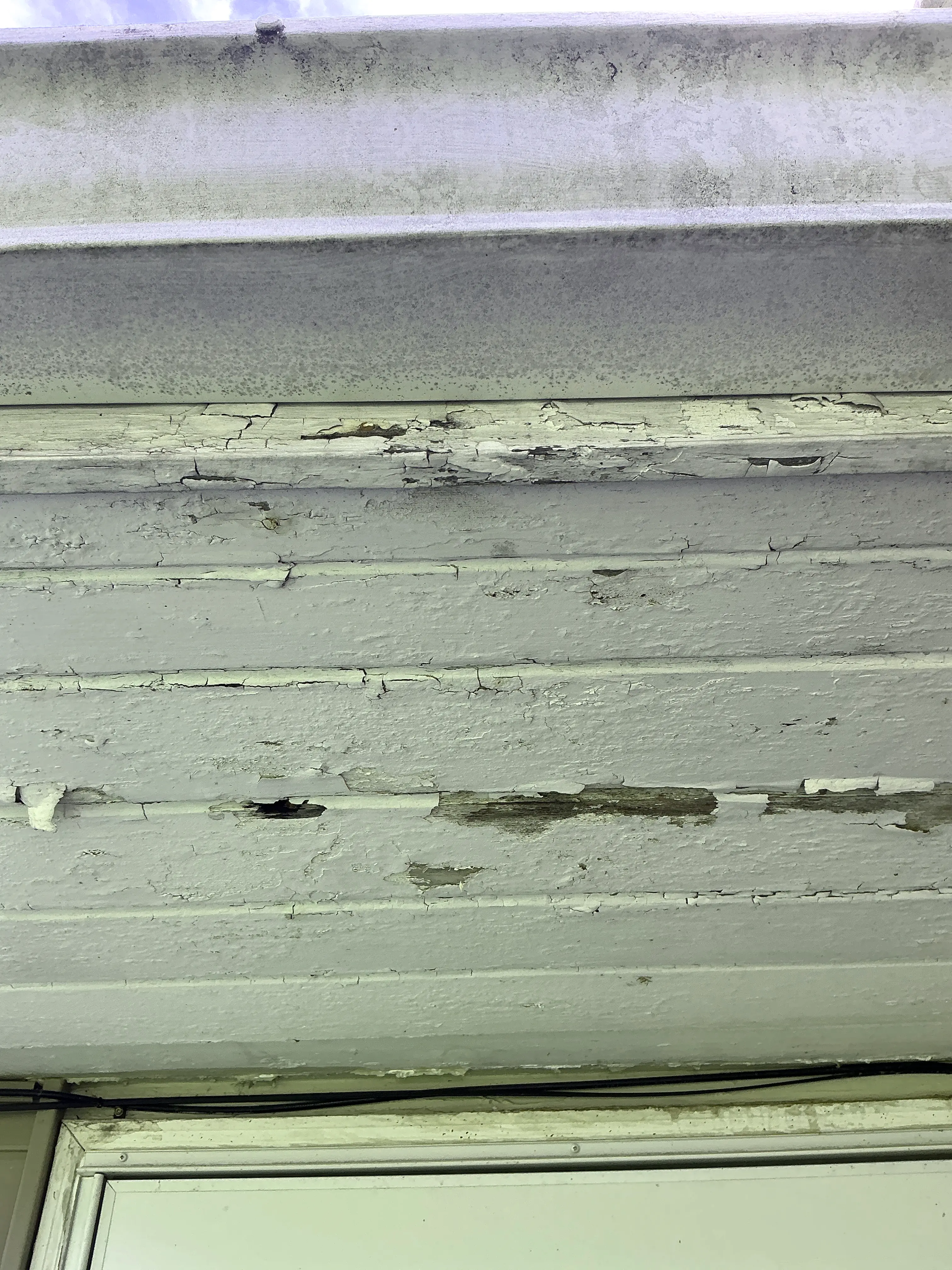 Peeling and cracked paint on exterior wood siding exposing weathered wood 2026-08-06
