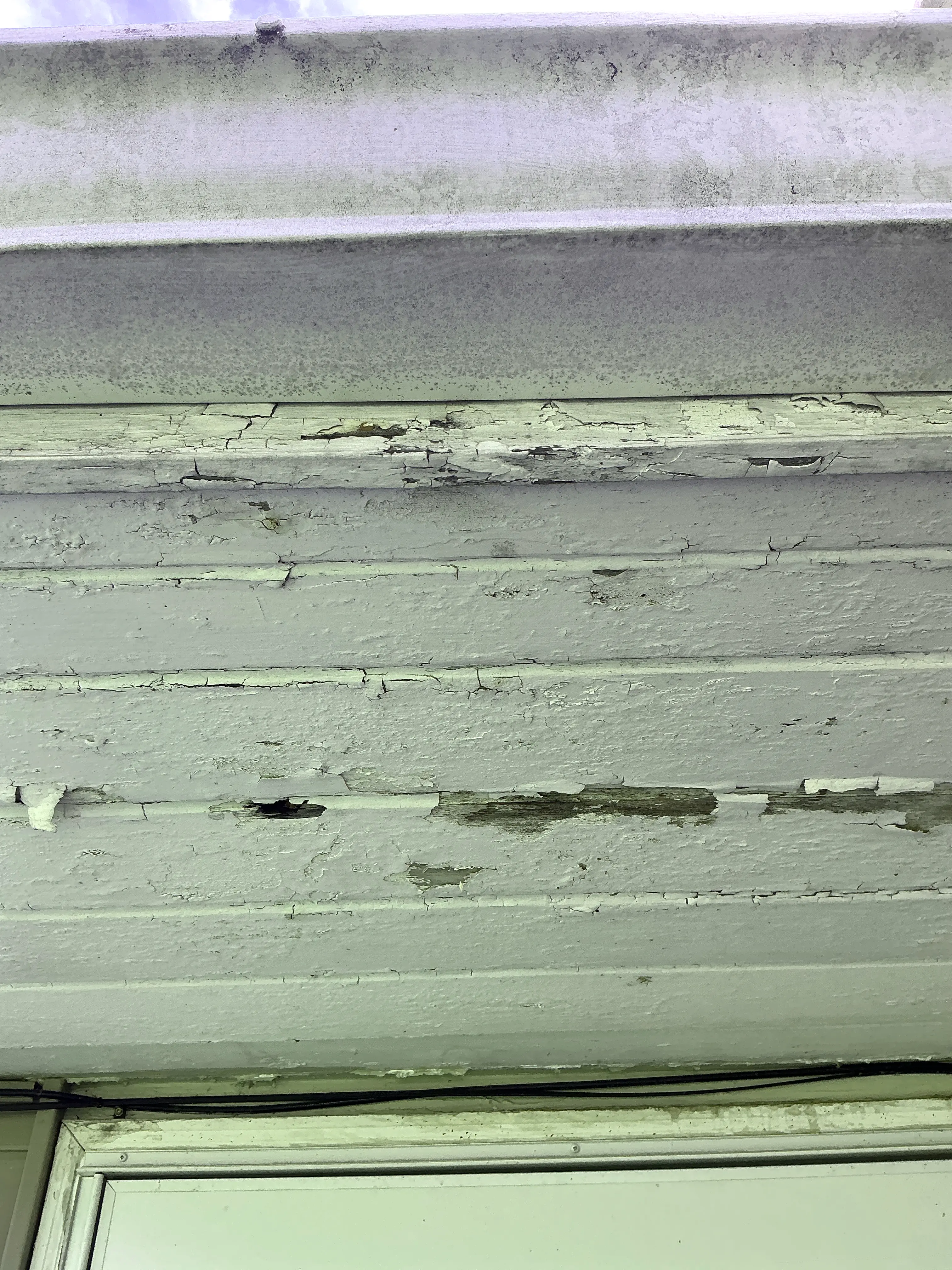 Peeling and cracked paint on exterior wood siding exposing weathered wood 2026-07-11