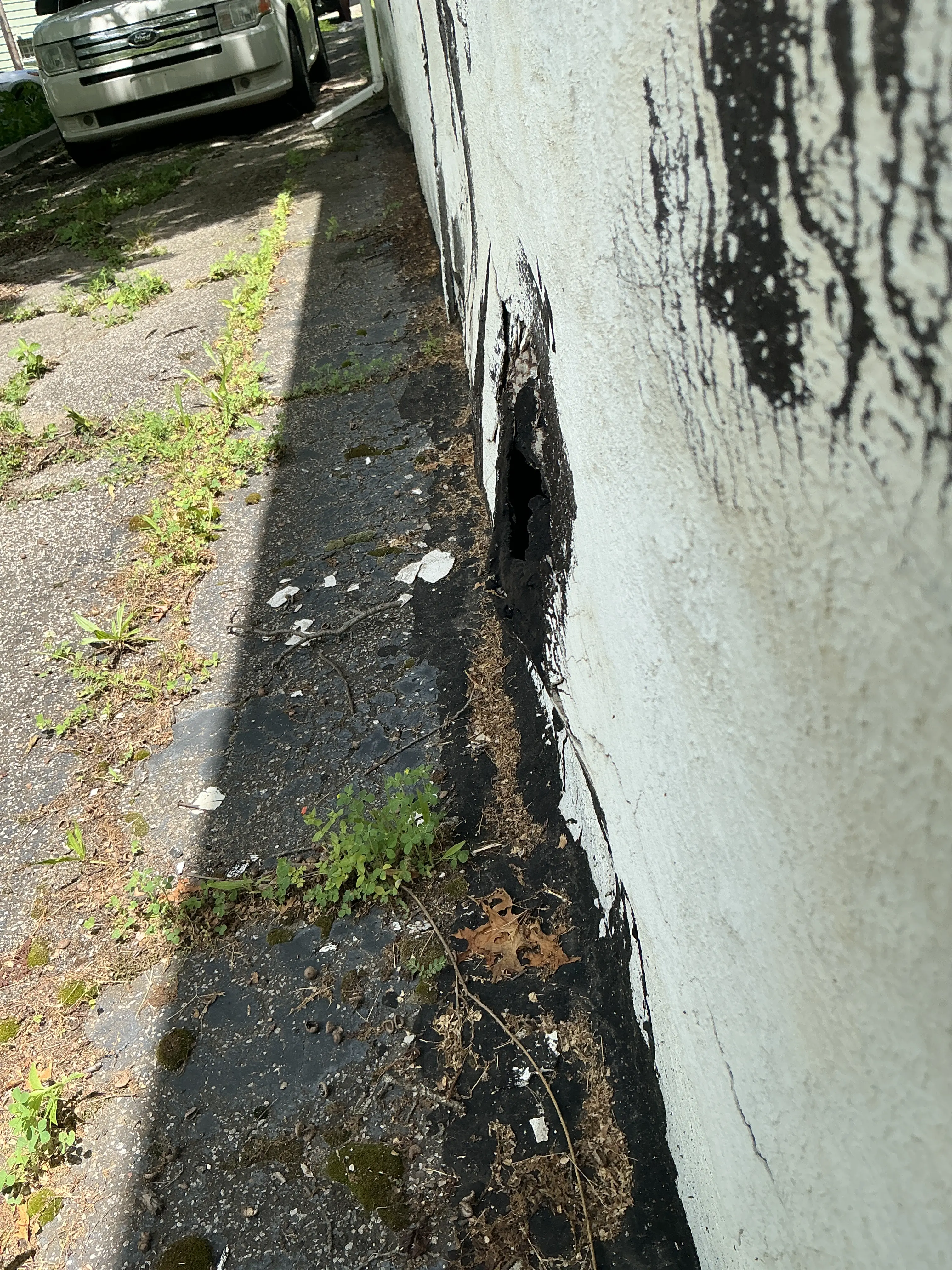 Hole at the base of exterior wall and foundation during indoor air quality testing 2026-08-07