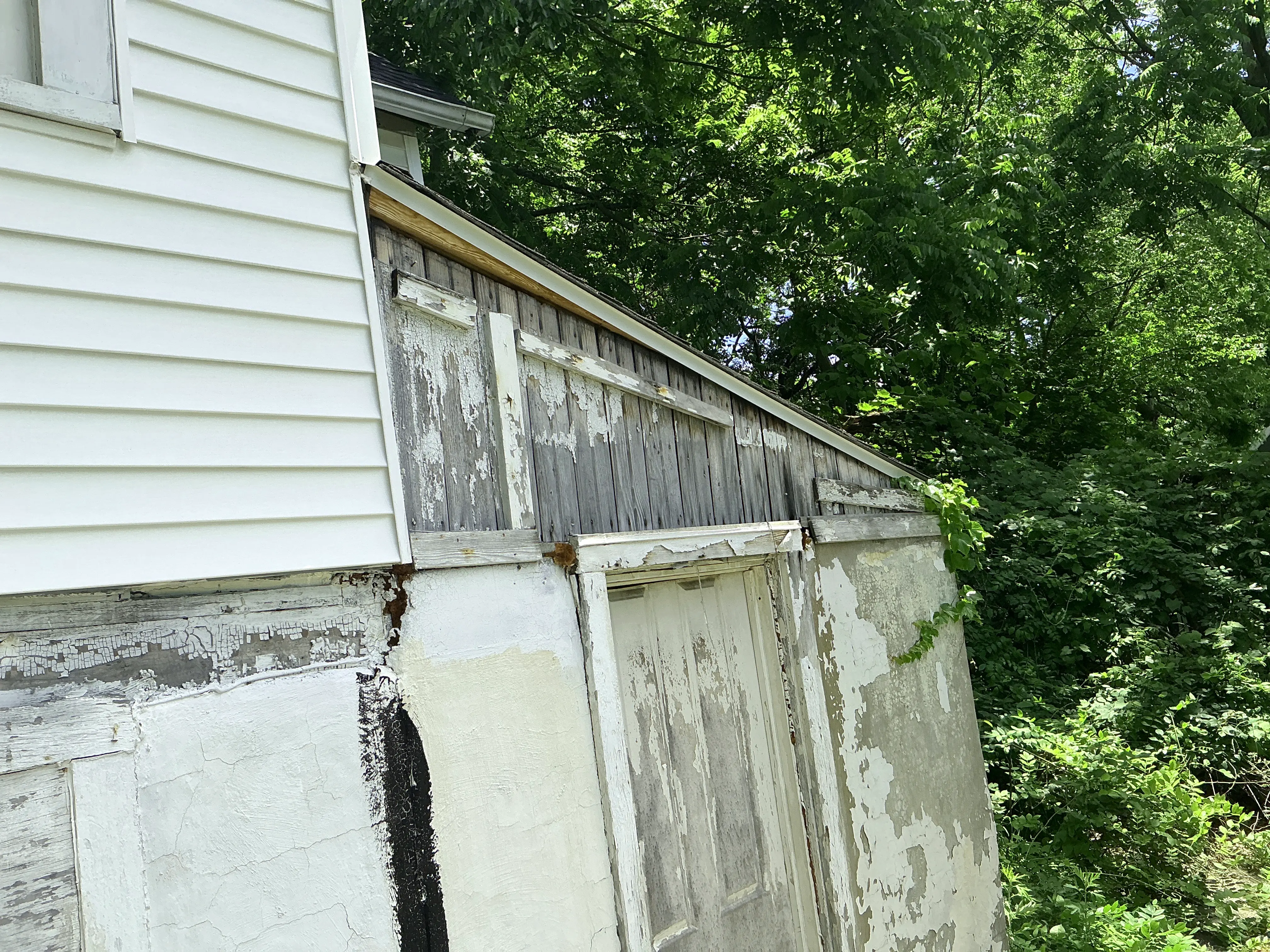 Severely peeling paint and weathered wood siding on an exterior wall 2026-07-05