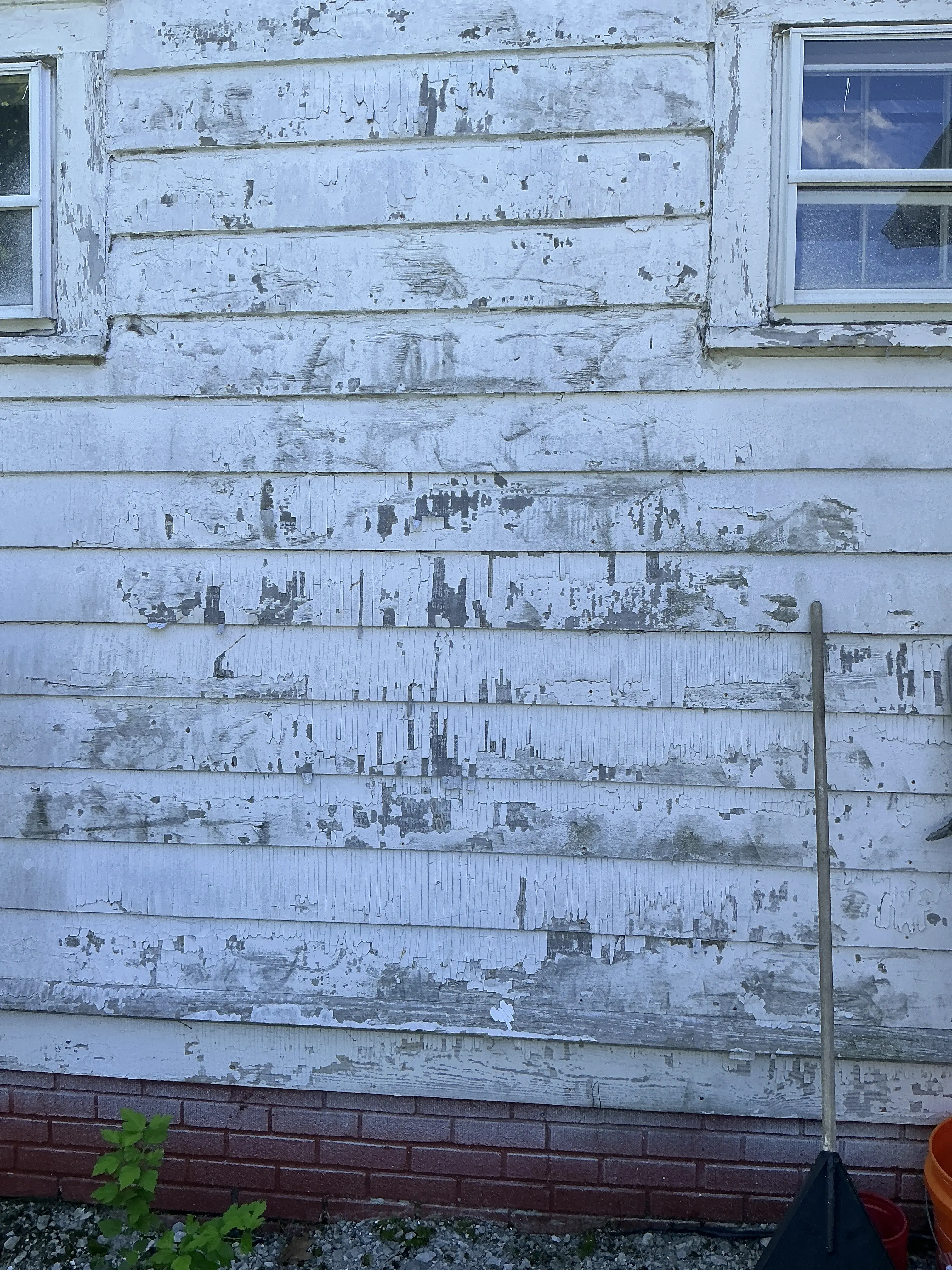 Peeling and cracking white paint on exterior wooden house siding 2026-07-31