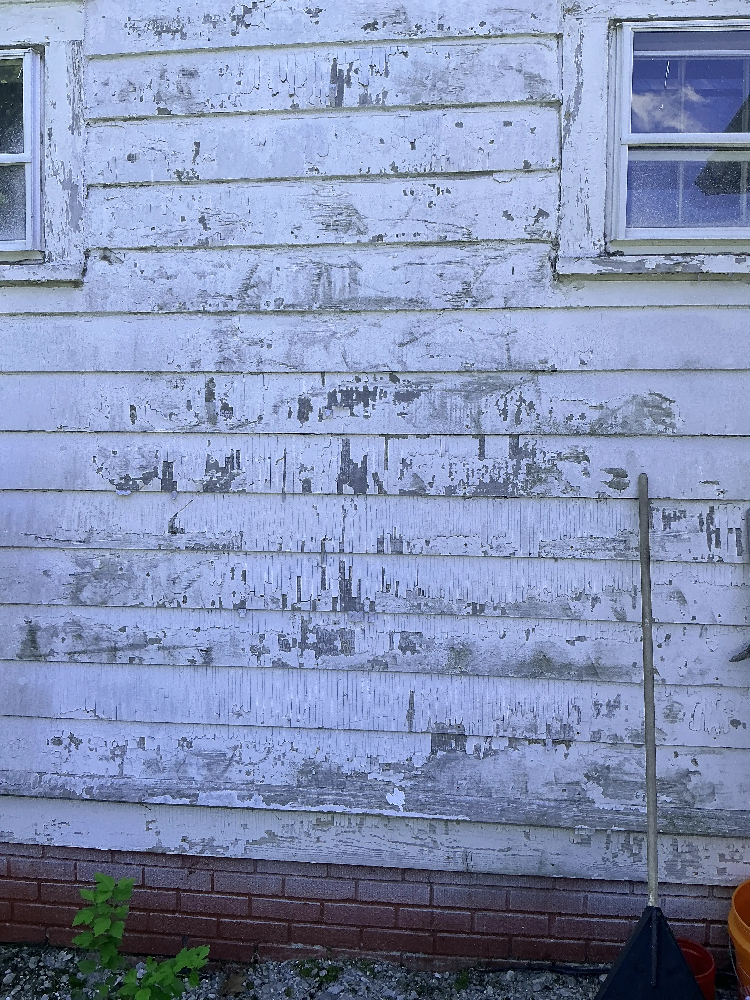 Peeling and cracking white paint on exterior wooden house siding 2026-08-13