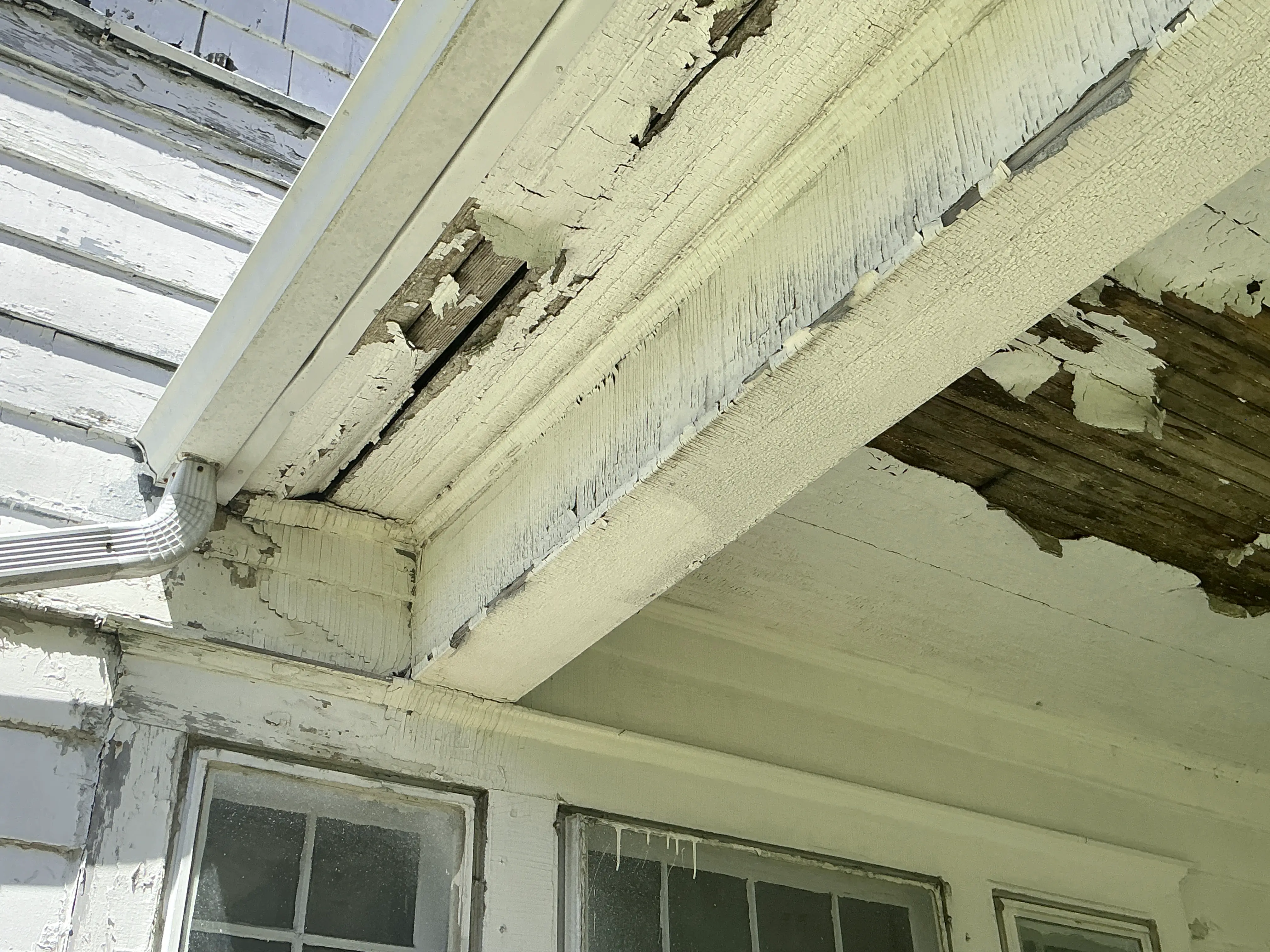 Rotted wood soffit and peeling exterior paint on a porch structure 2026-07-15
