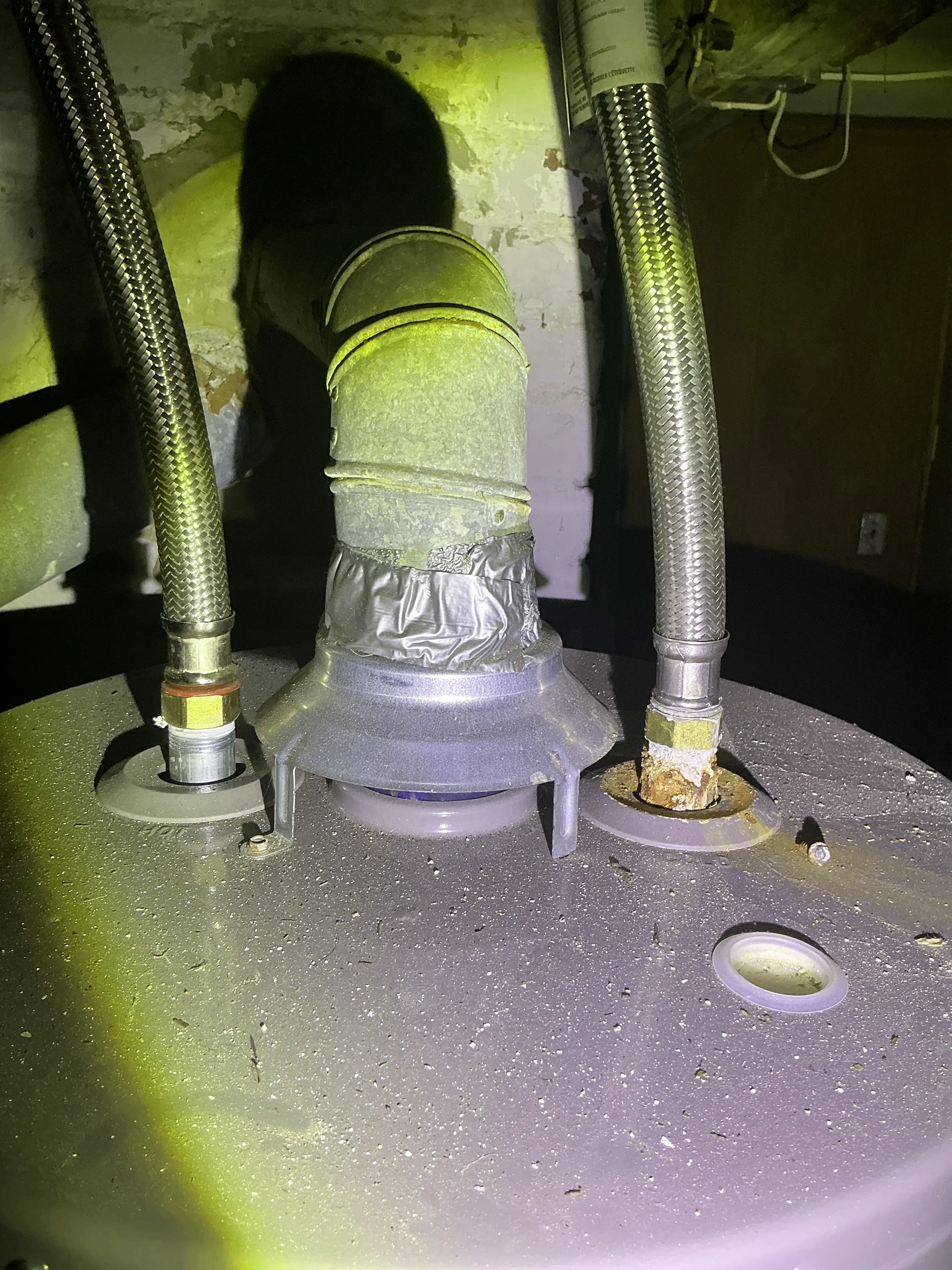 Corroded plumbing connection and taped vent pipe on top of a gas water heater 2026-08-12