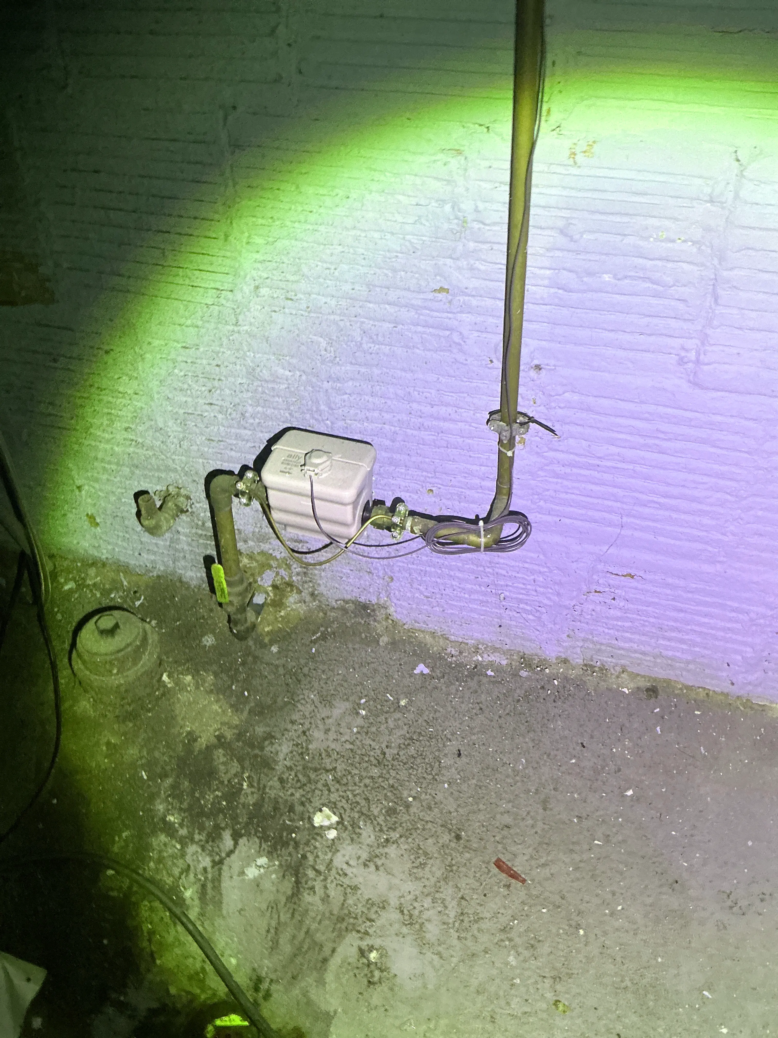 Water main shutoff valve and meter assembly with electrical bonding wire in a basement 2026-08-31