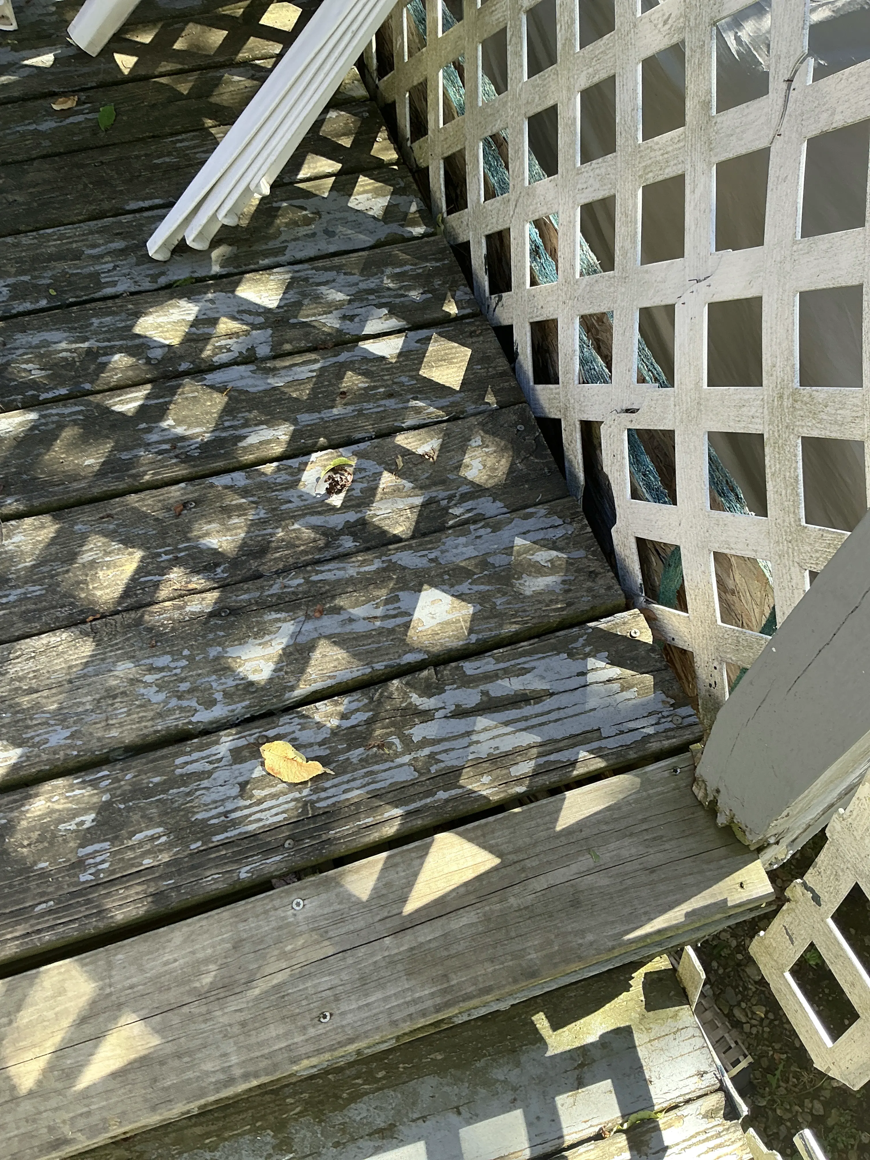 Peeling paint and weathered wood decking on an outdoor porch 2026-07-10