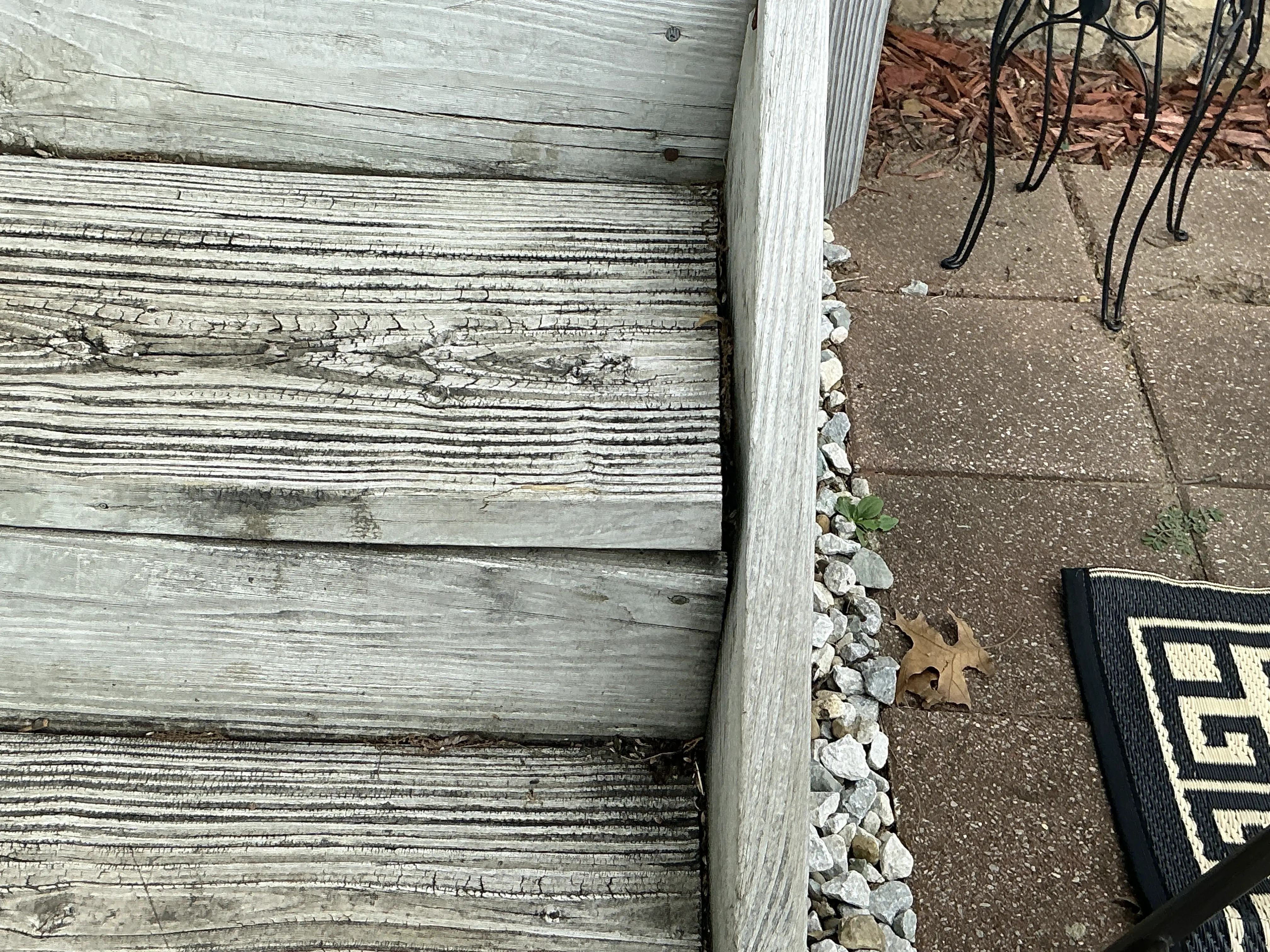 Weathered exterior wooden stair steps showing surface cracks and wood grain deterioration 2026-08-17