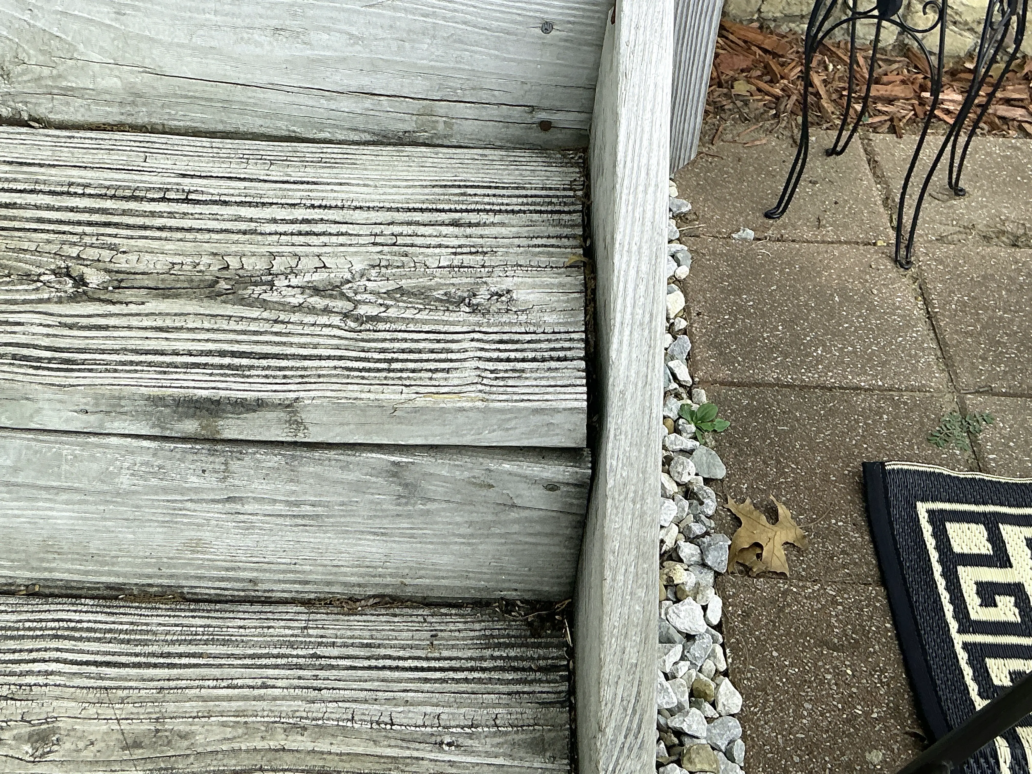 Weathered exterior wooden stair steps showing surface cracks and wood grain deterioration 2026-08-13