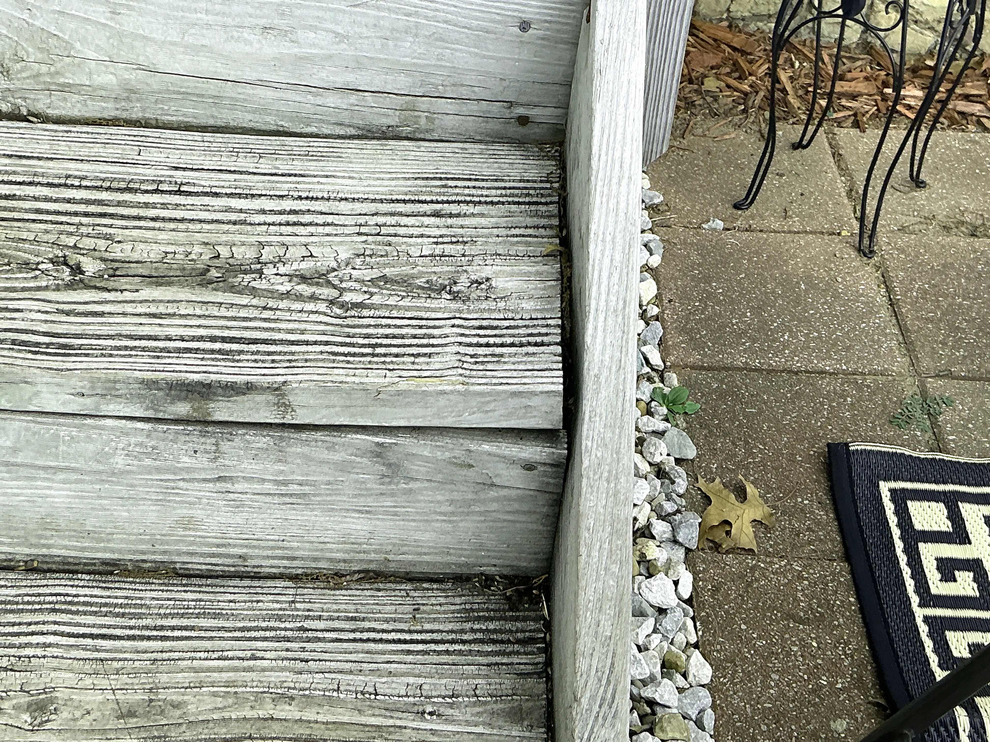 Weathered exterior wooden stair steps showing surface cracks and wood grain deterioration 2026-08-12