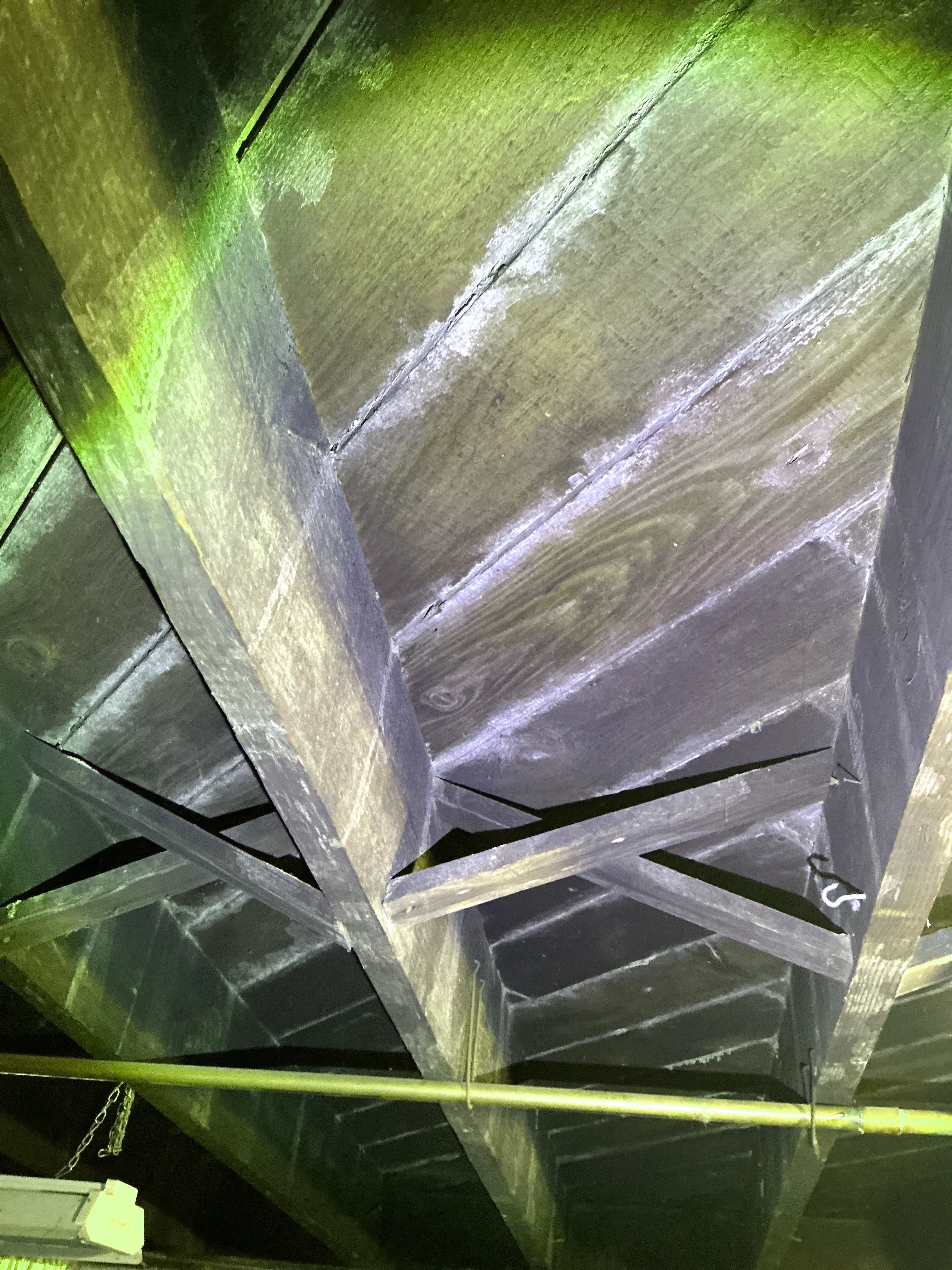 Moisture staining and white mold or mineral residue on attic wooden framing during home inspection 2026-08-24