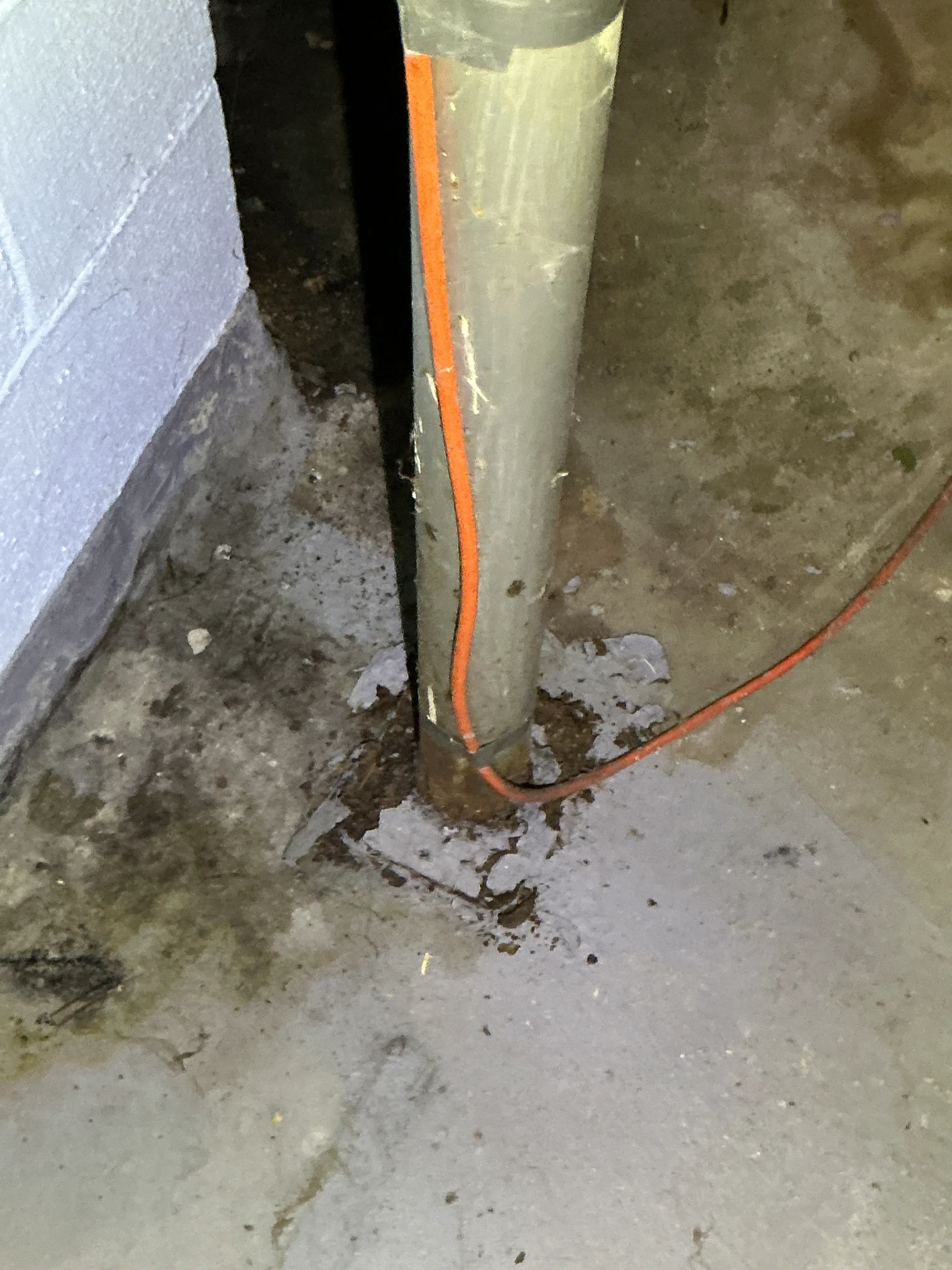 Deteriorated pipe penetration seal on concrete basement floor with orange heat cable 2026-08-21