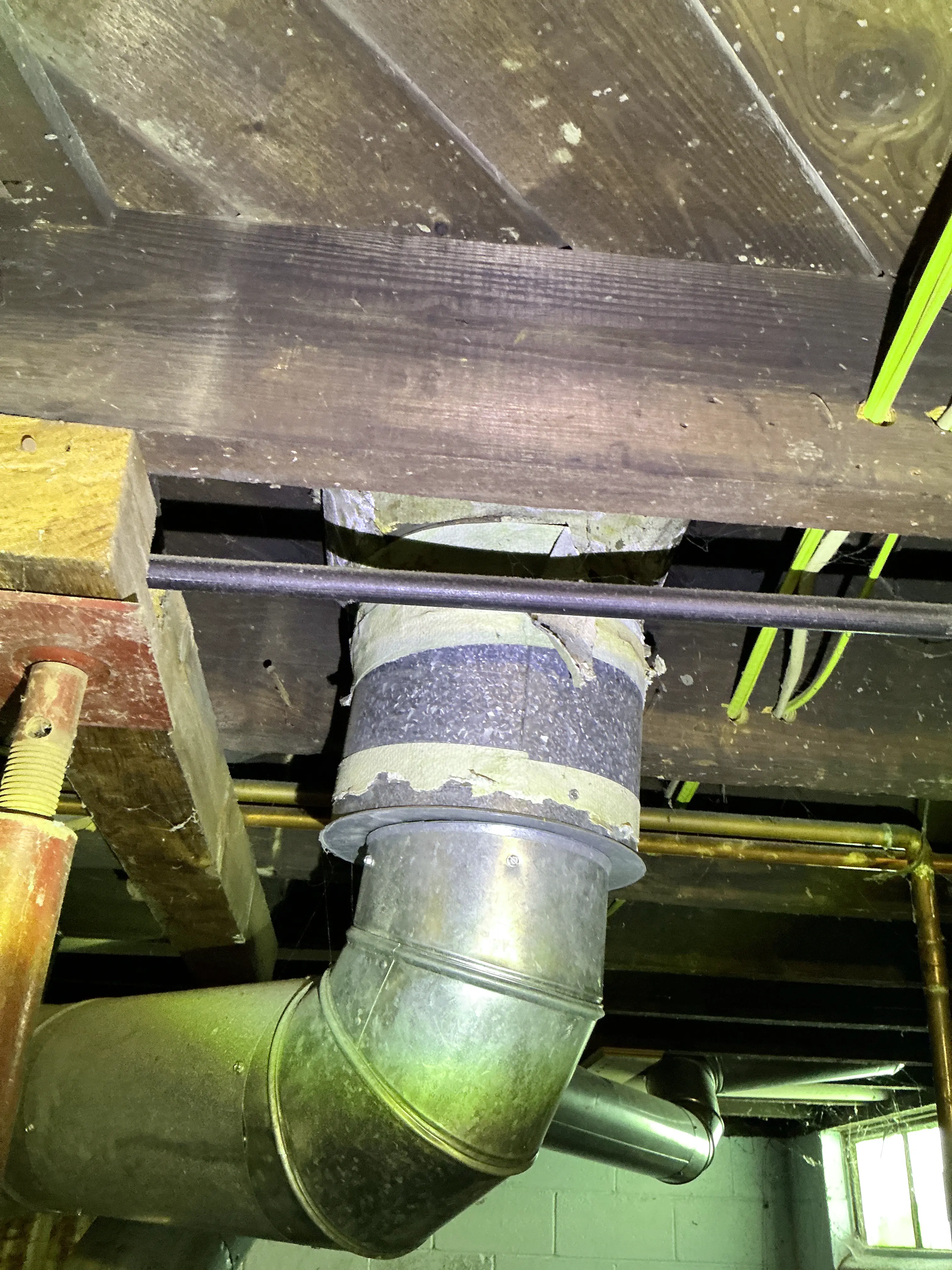 Deteriorating asbestos paper insulation tape on metal ductwork in a basement 2026-07-08