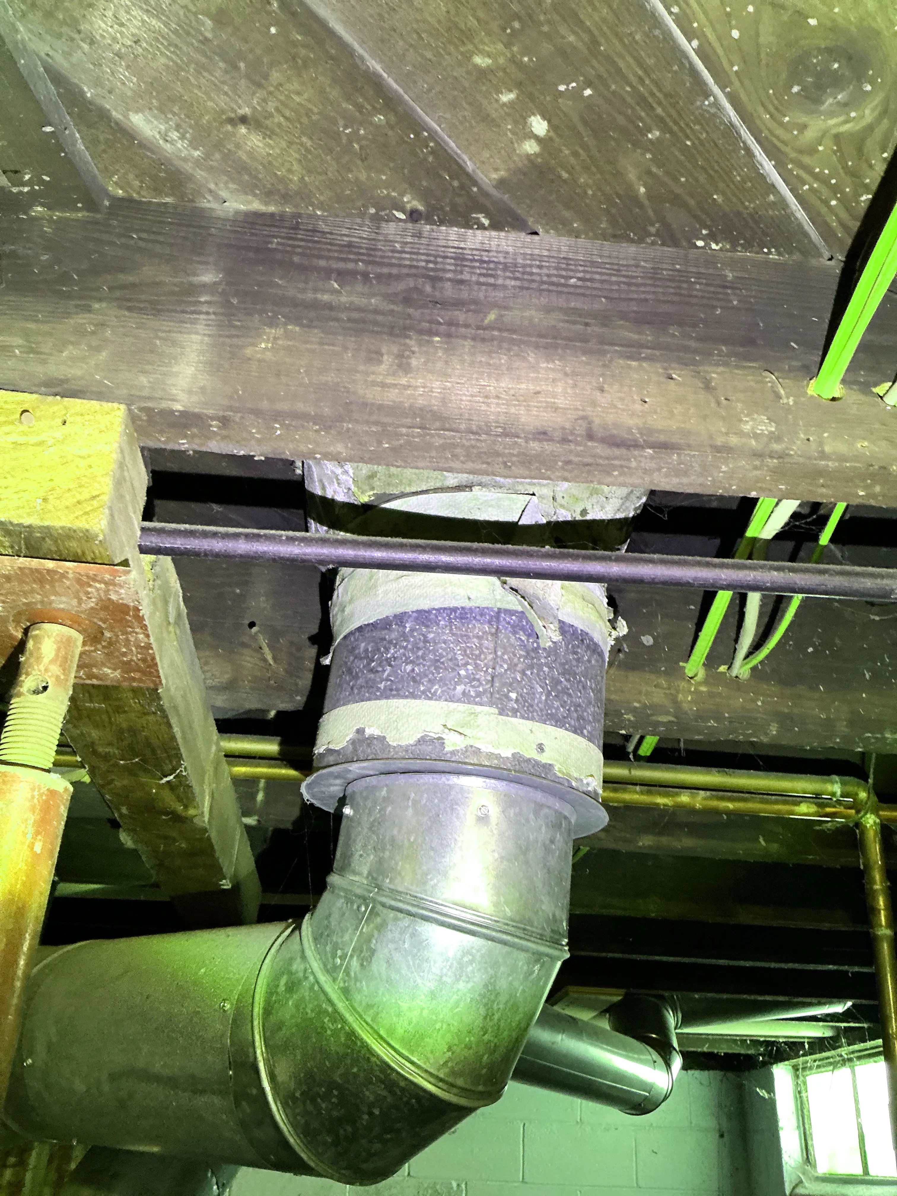 Deteriorating asbestos paper insulation tape on metal ductwork in a basement 2026-08-23