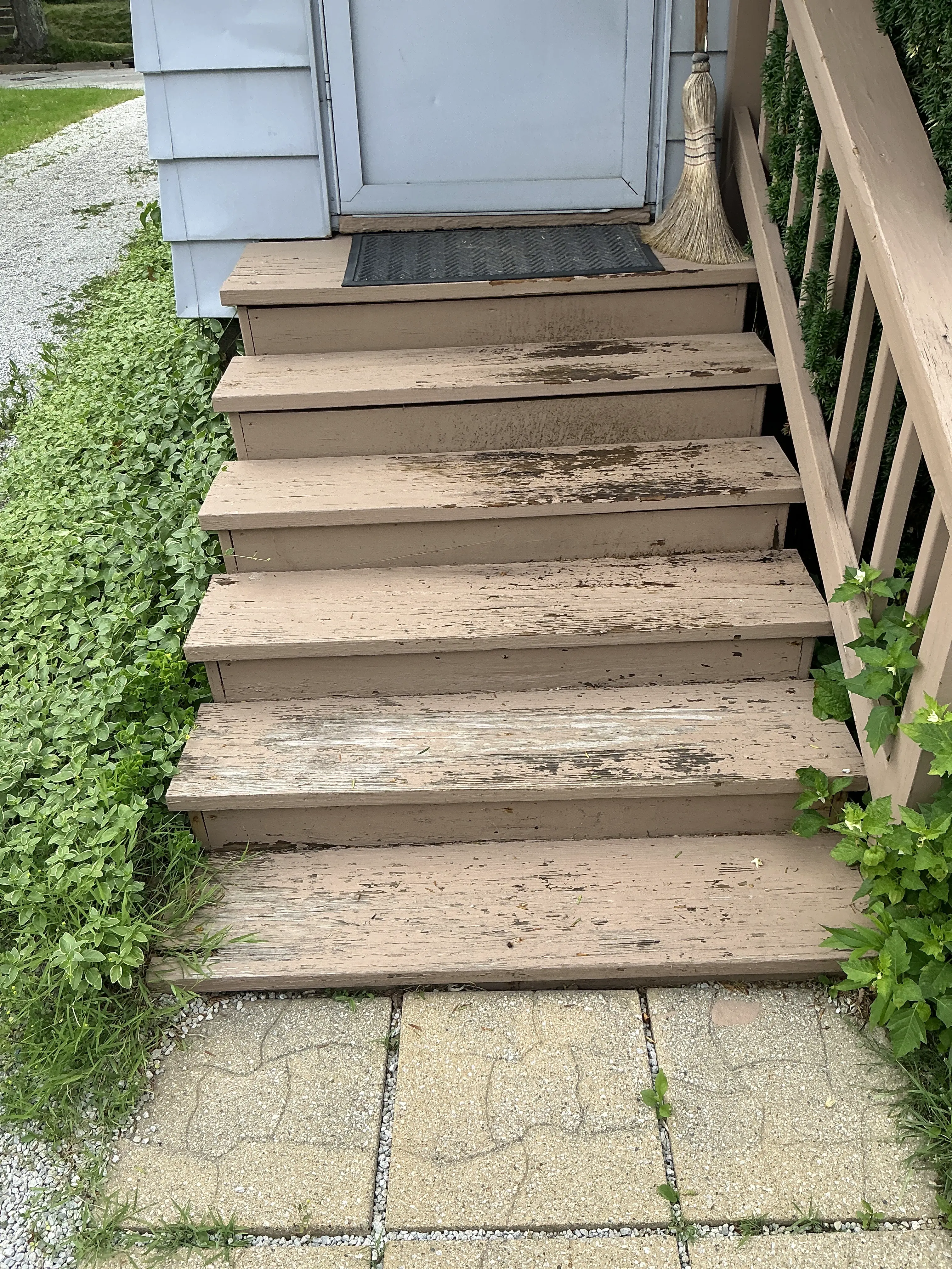 Peeling paint and weathered wood on exterior wooden deck stairs 2026-07-19