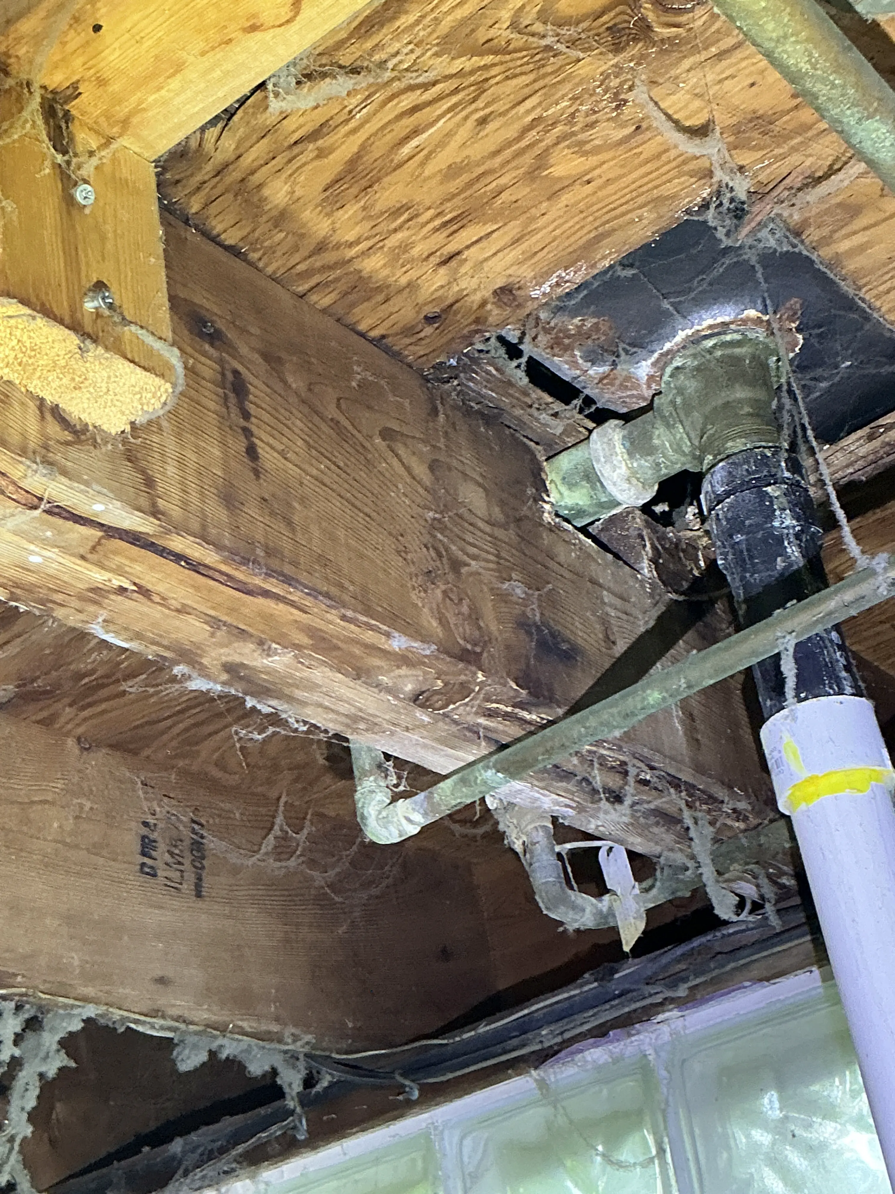 Improperly notched floor joist around plumbing pipes in crawlspace 2026-08-03
