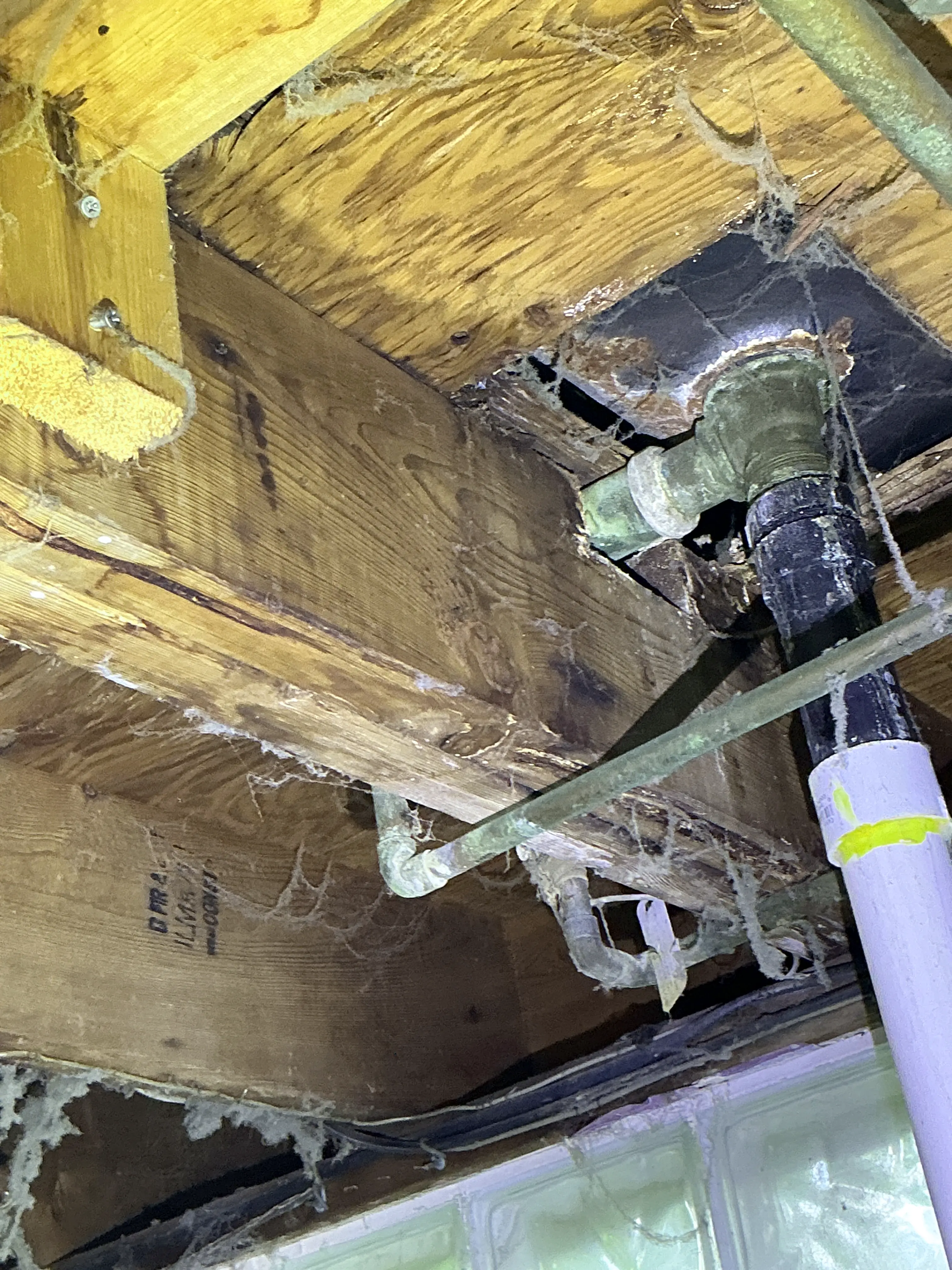Improperly notched floor joist around plumbing pipes in crawlspace 2026-07-24