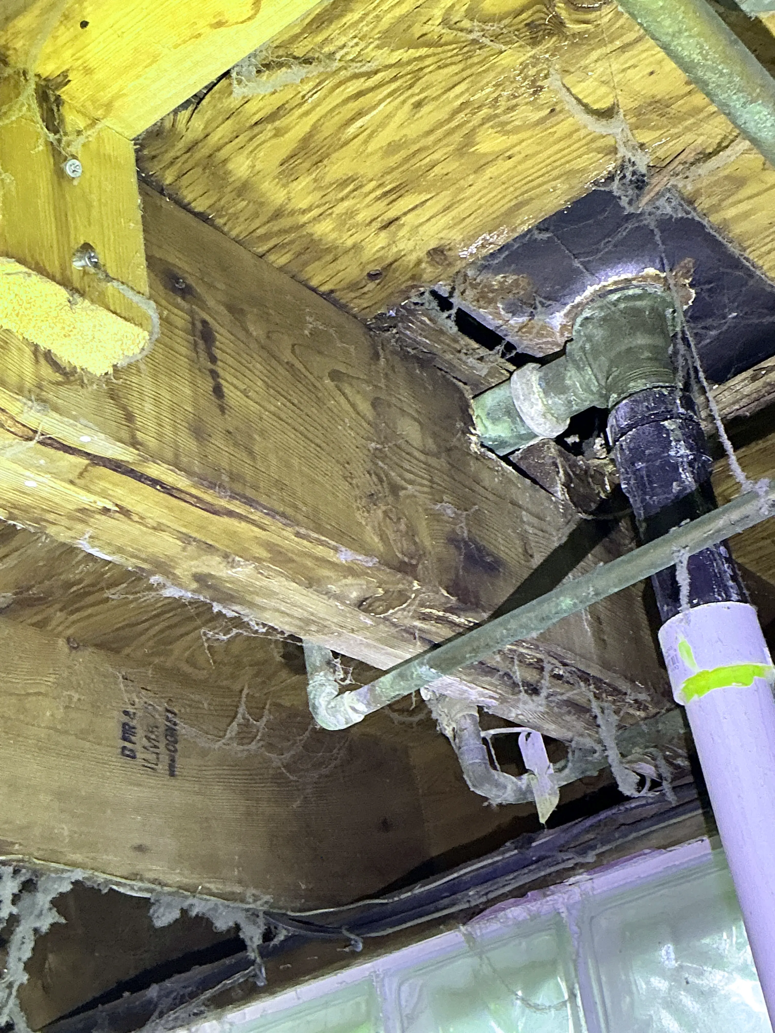 Improperly notched floor joist around plumbing pipes in crawlspace 2026-07-26
