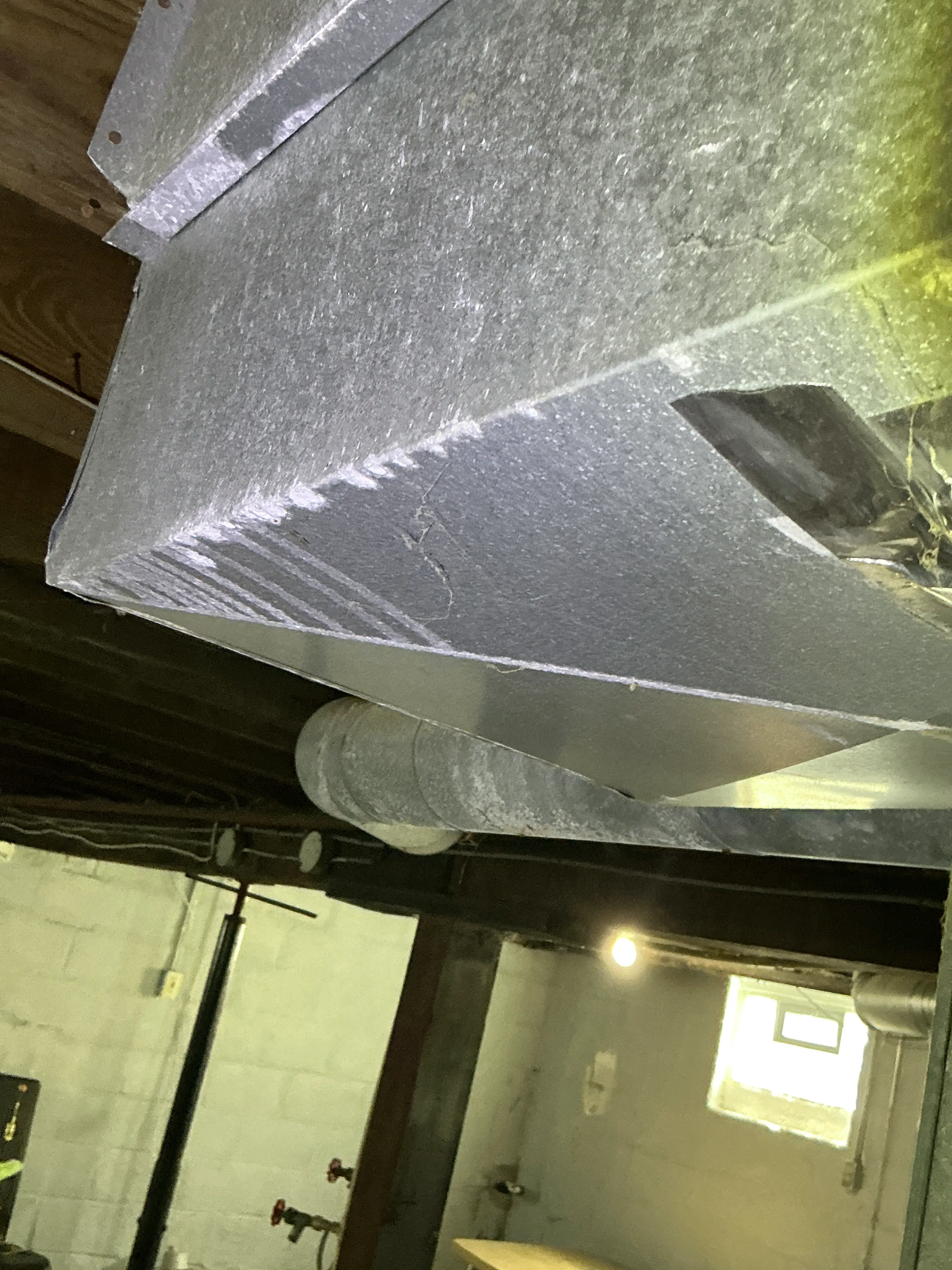 Galvanized sheet metal HVAC ductwork in a basement ceiling during a home inspection 2026-08-20