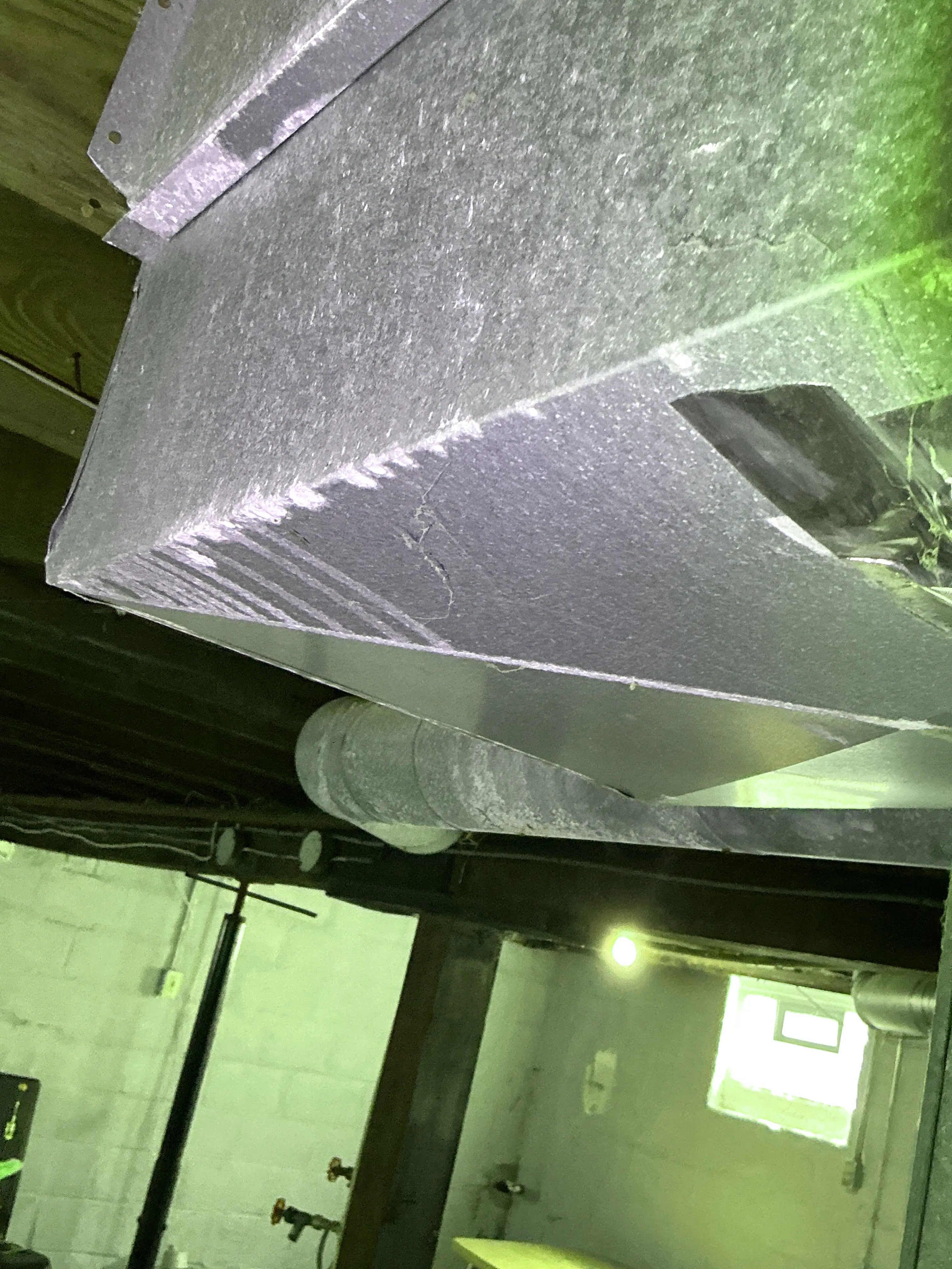 Galvanized sheet metal HVAC ductwork in a basement ceiling during a home inspection 2026-08-26