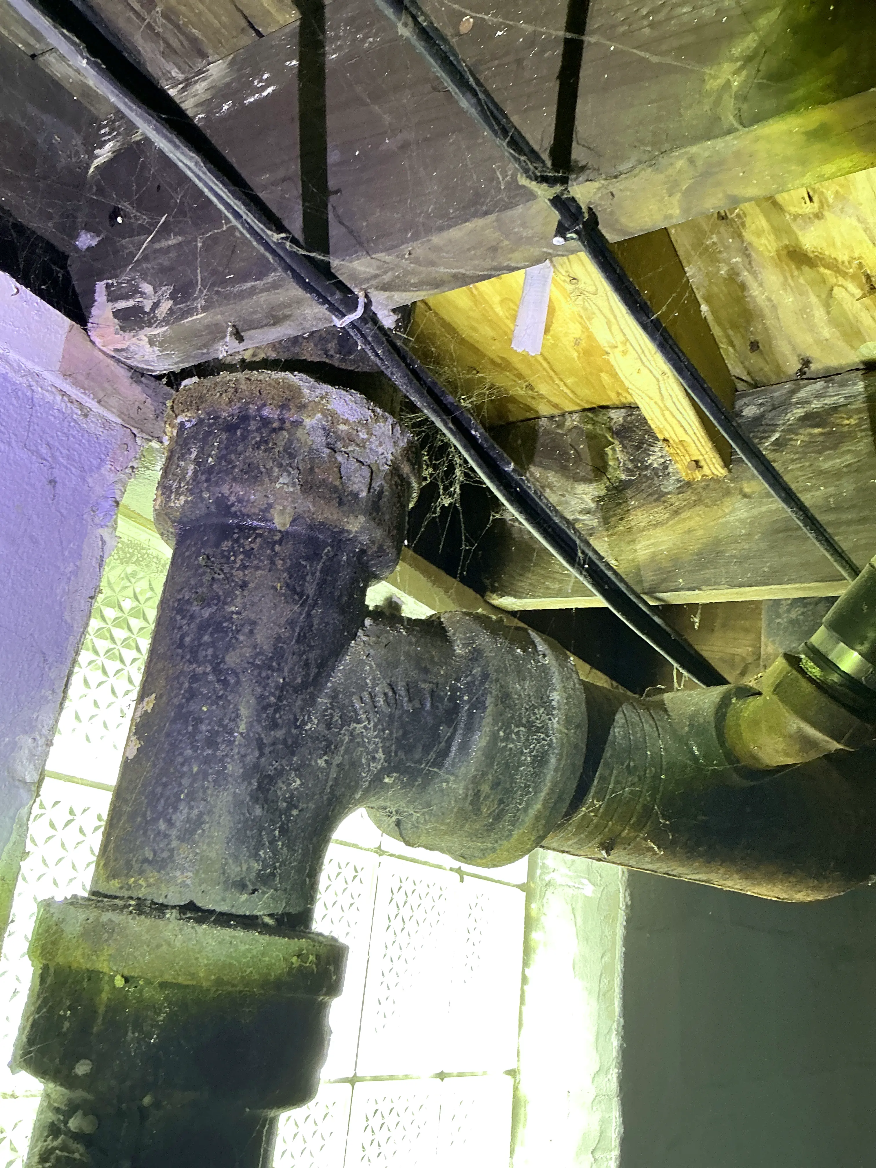 Corroded cast iron drain pipe fitting in basement crawlspace 2026-08-23
