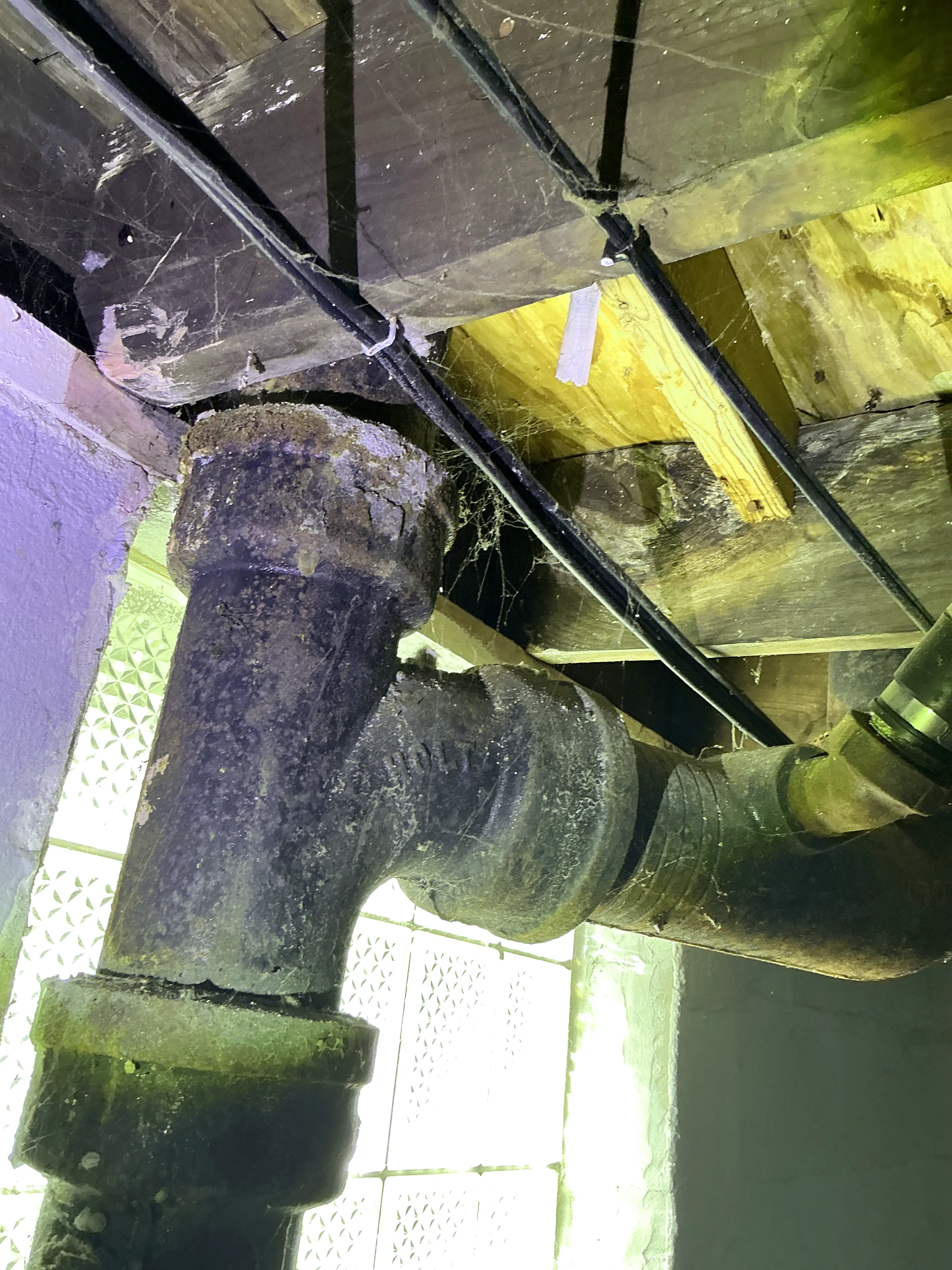 Corroded cast iron drain pipe fitting in basement crawlspace 2026-07-30