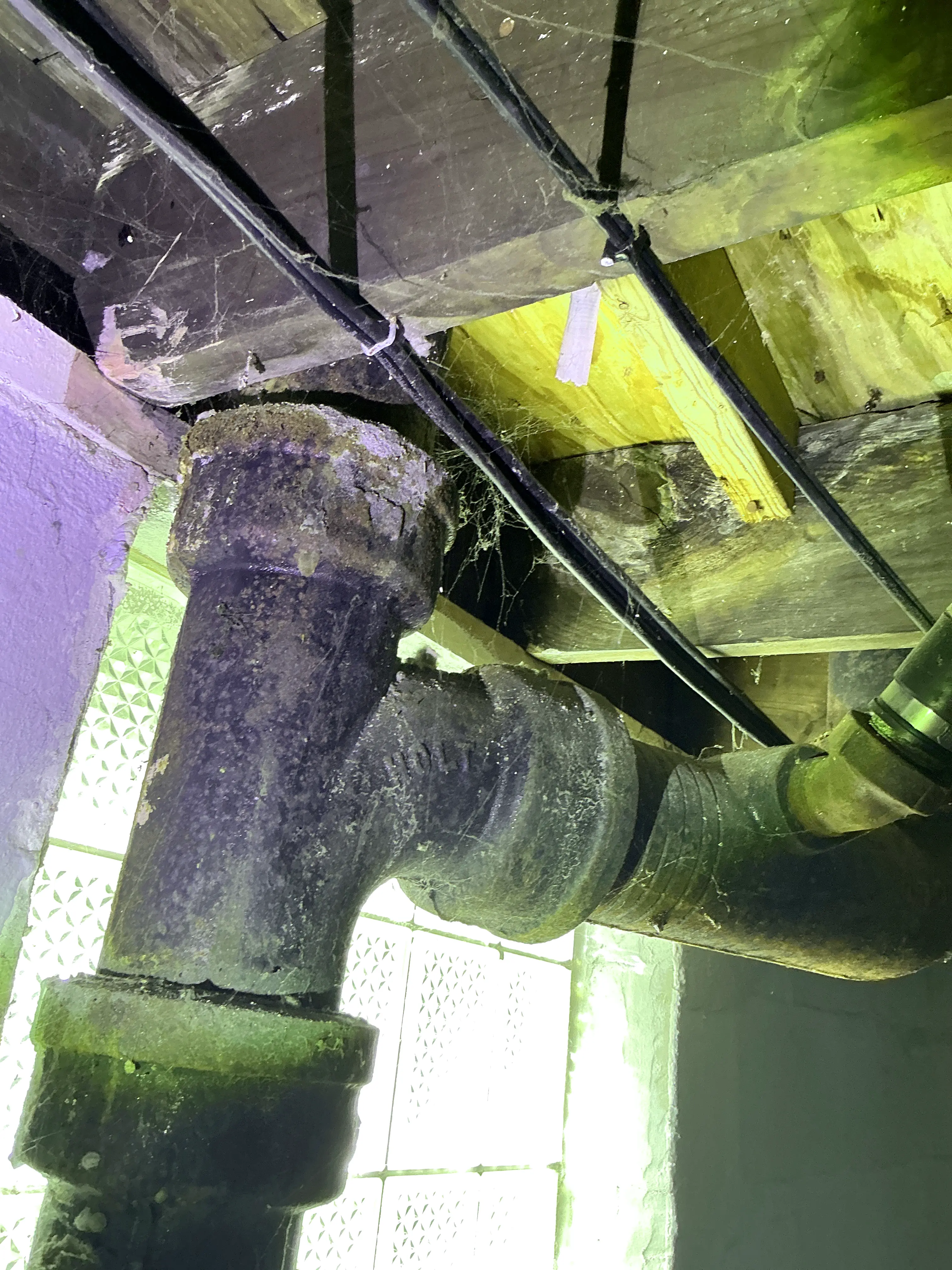 Corroded cast iron drain pipe fitting in basement crawlspace 2026-07-20