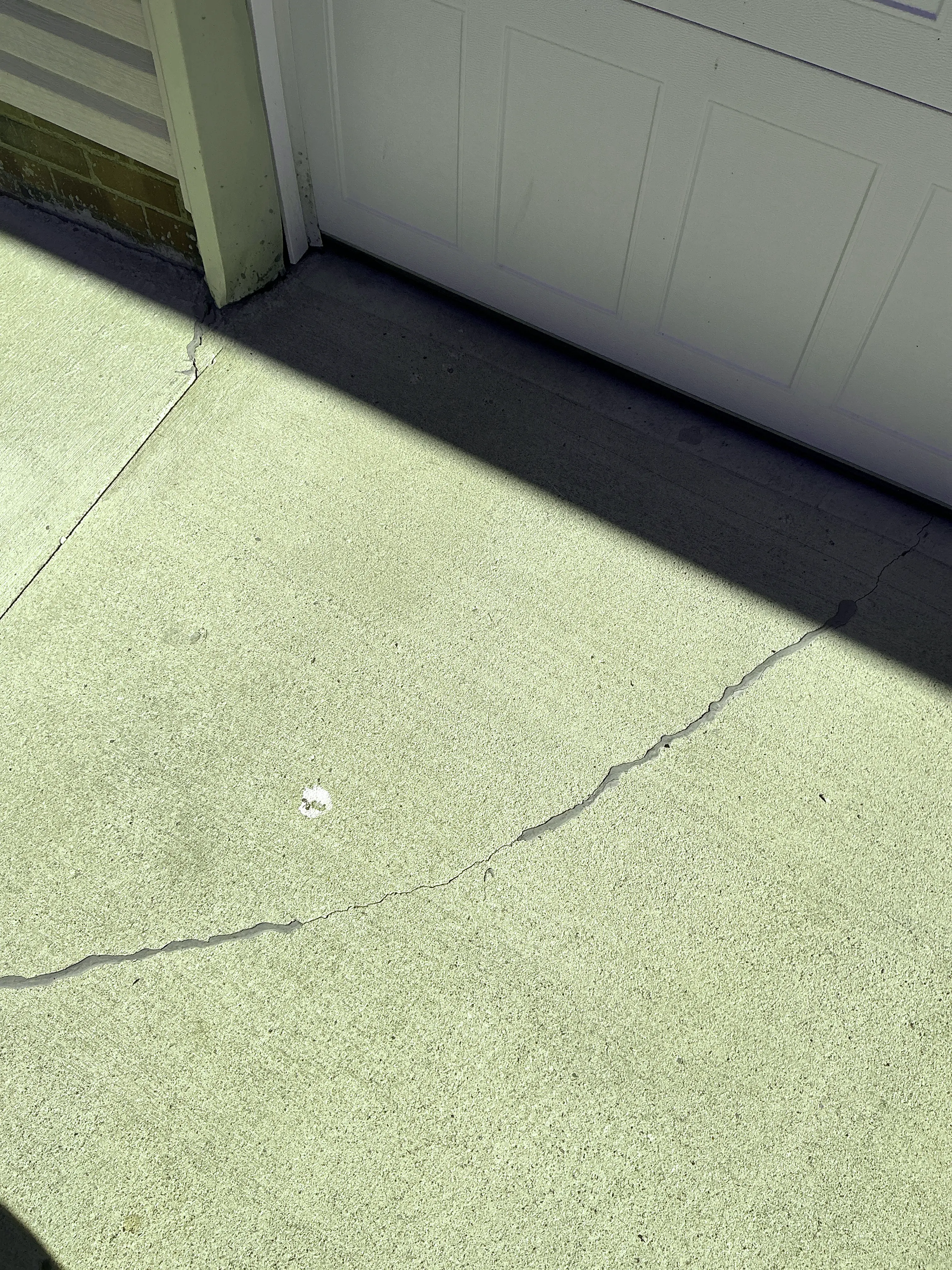Sealed concrete crack on a driveway near a garage door 2026-07-24