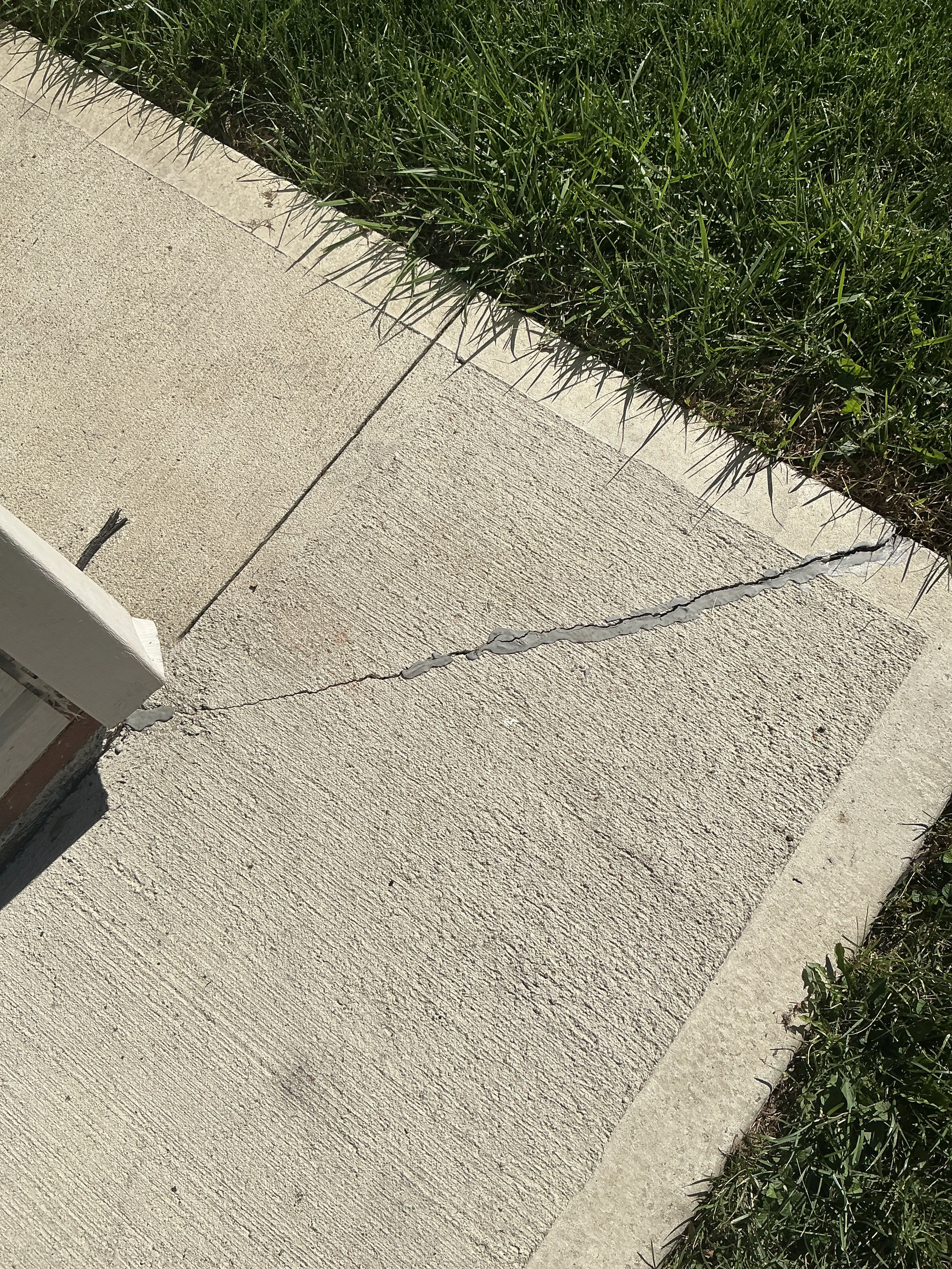 Cracked concrete walkway slab with caulk repair 2026-08-29