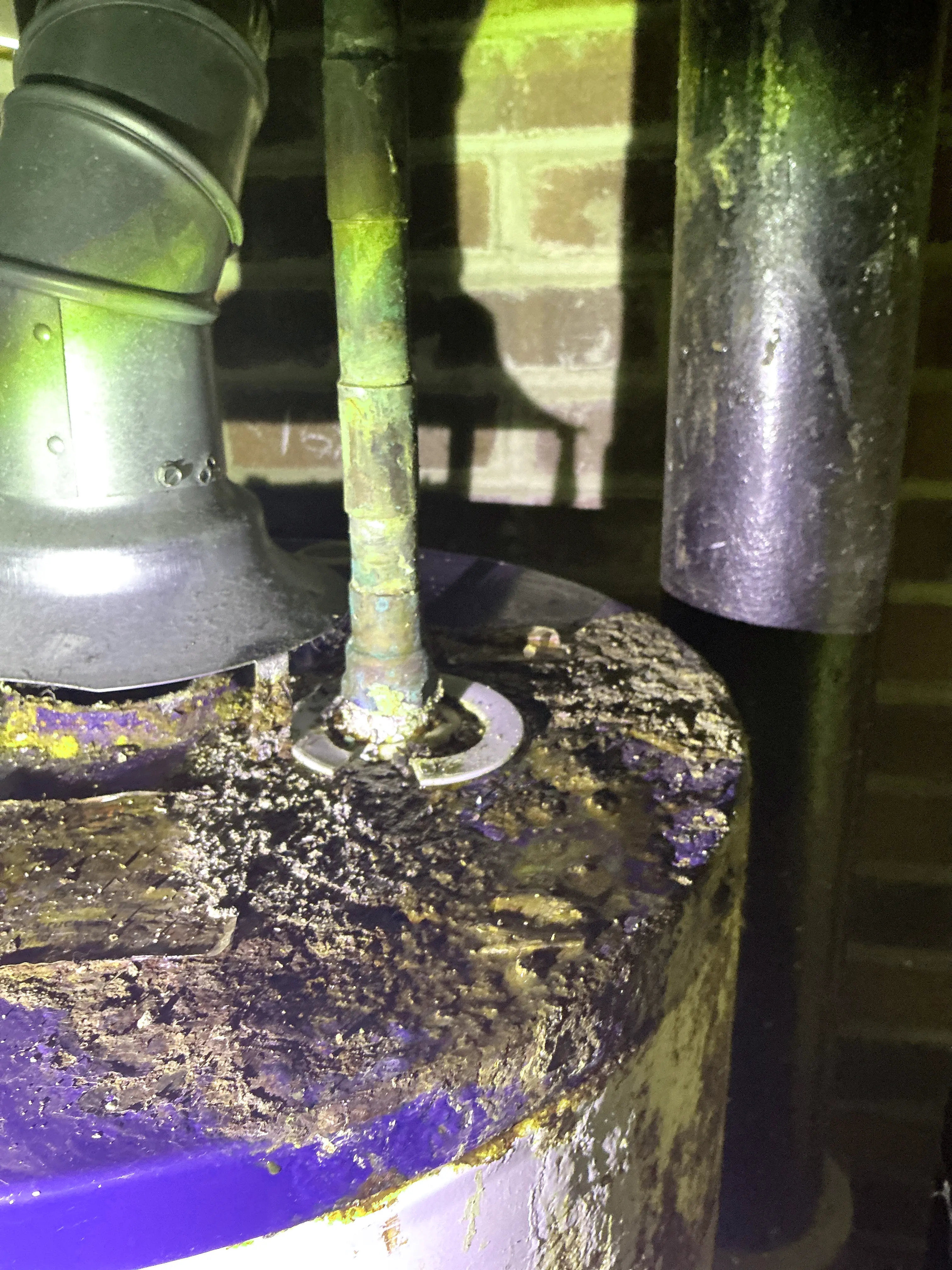 Severe corrosion and rust buildup on top of a water heater near copper pipe fitting 2026-08-24