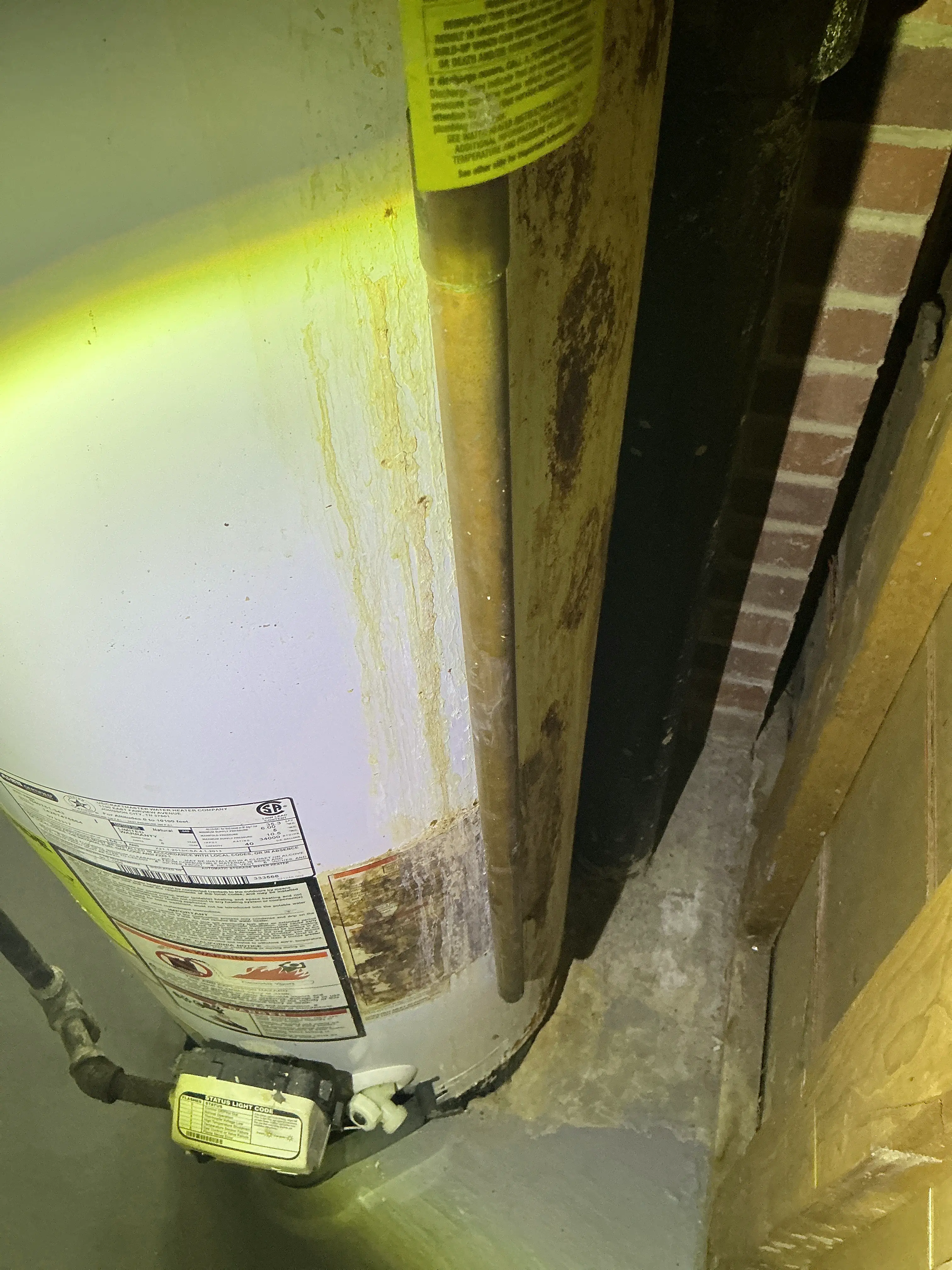 Corroded water heater tank with heavy rust and water leak stains 2026-07-12