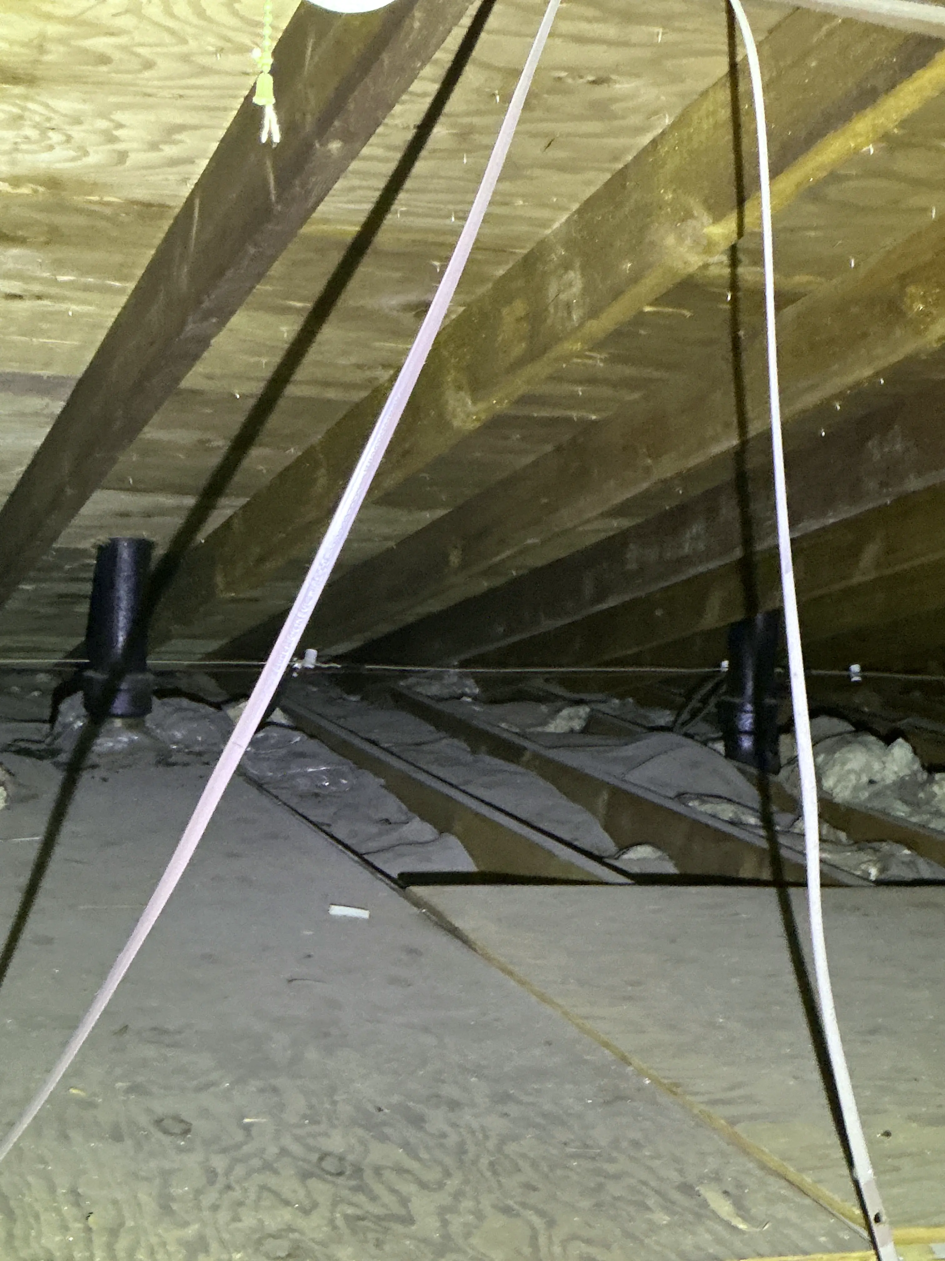 Unfinished attic framing featuring electrical wiring, insulation, and plumbing vents during a general inspection. 2026-08-06