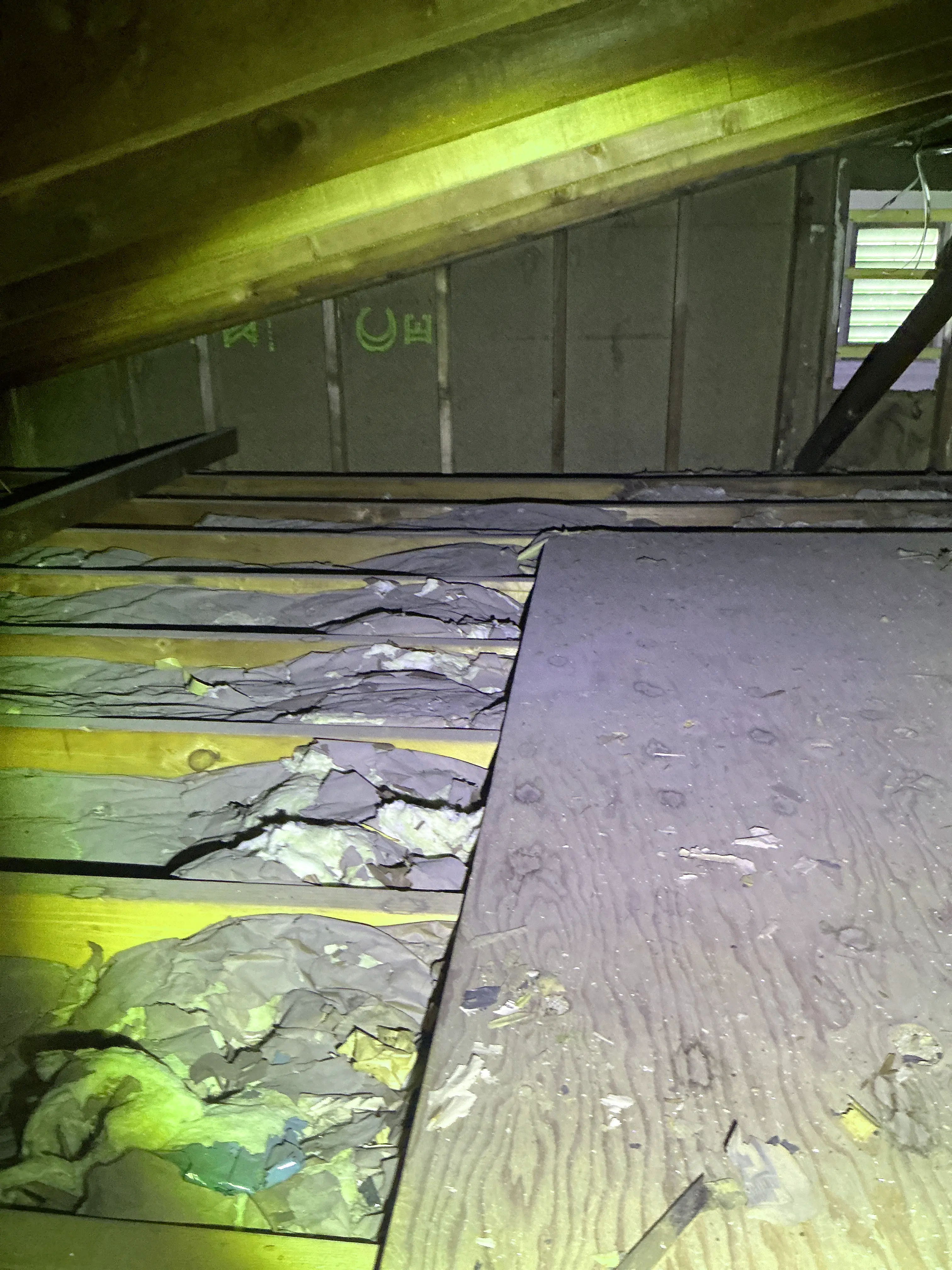 Damaged and exposed fiberglass wall insulation inside an unfinished attic space 2026-08-27