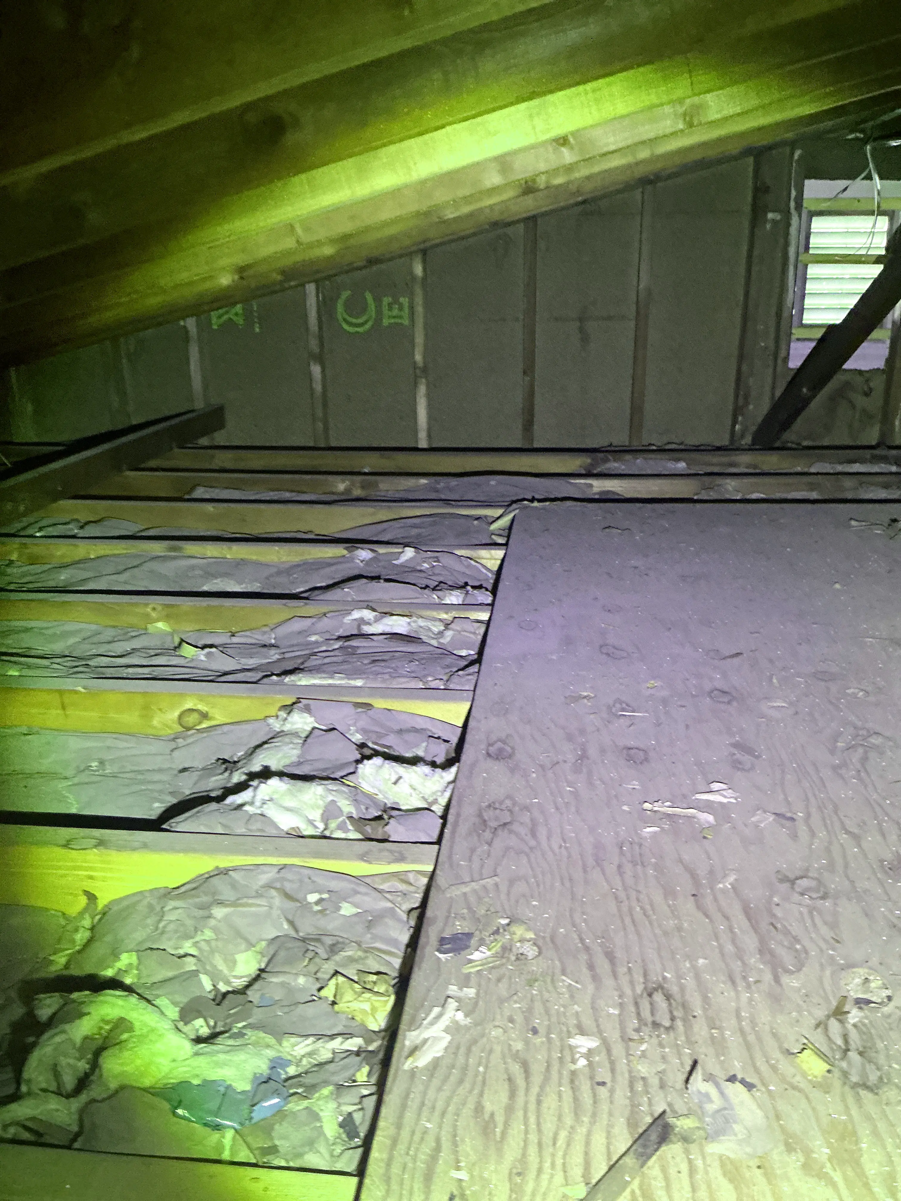 Damaged and exposed fiberglass wall insulation inside an unfinished attic space 2026-08-03