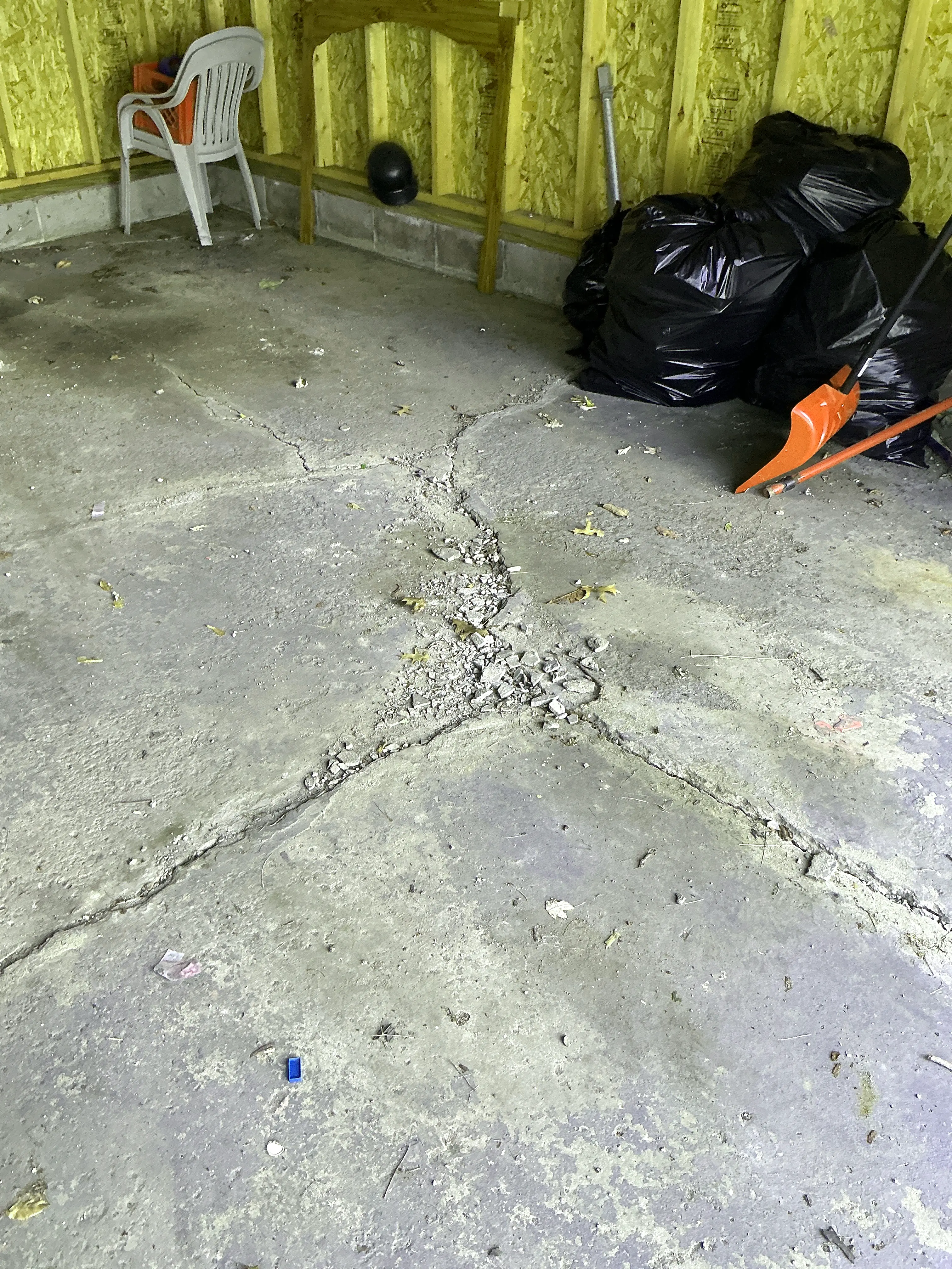 Cracked and crumbling concrete slab floor in garage 2026-07-23