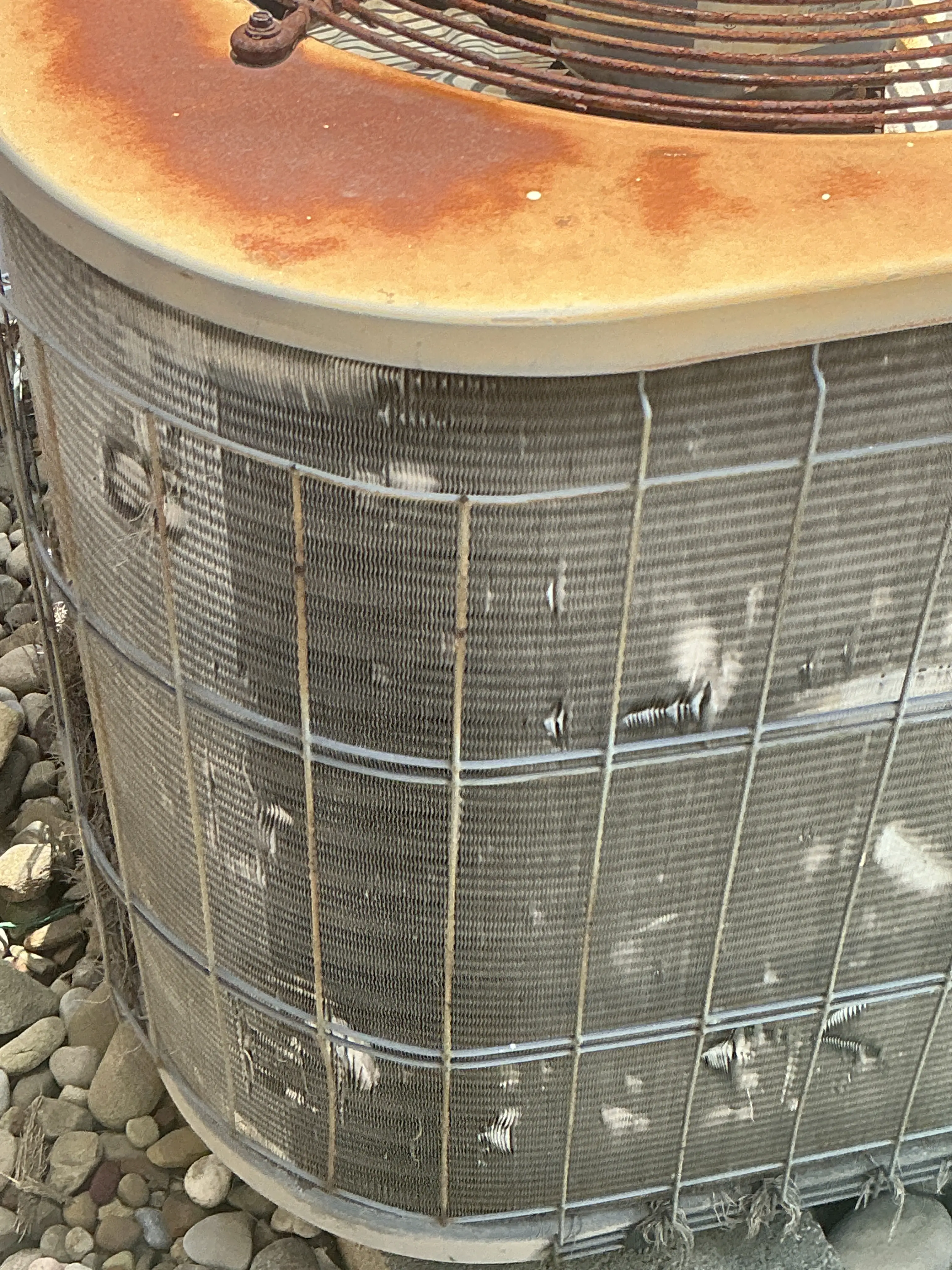 Damaged air conditioner condenser coil fins and rusty exterior panel 2026-07-17