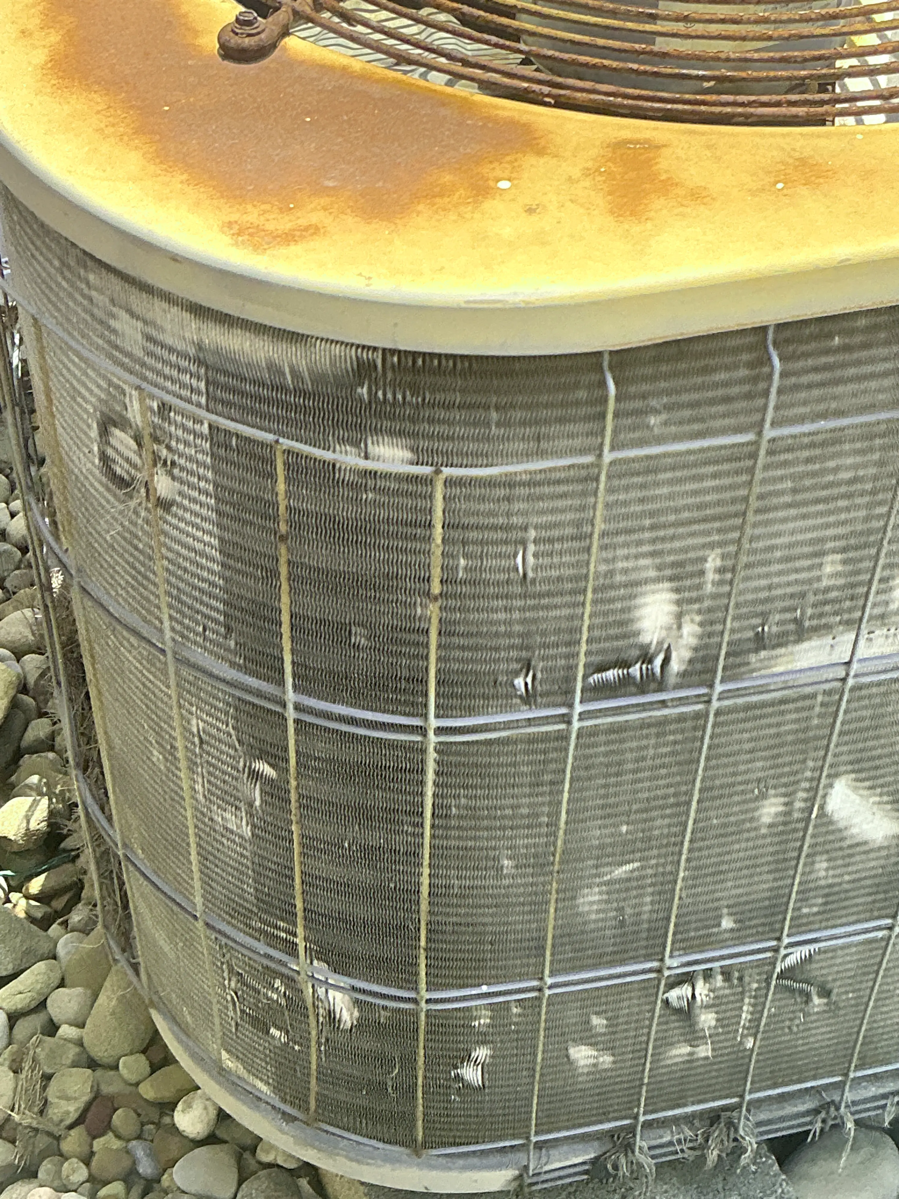 Damaged air conditioner condenser coil fins and rusty exterior panel 2026-08-10