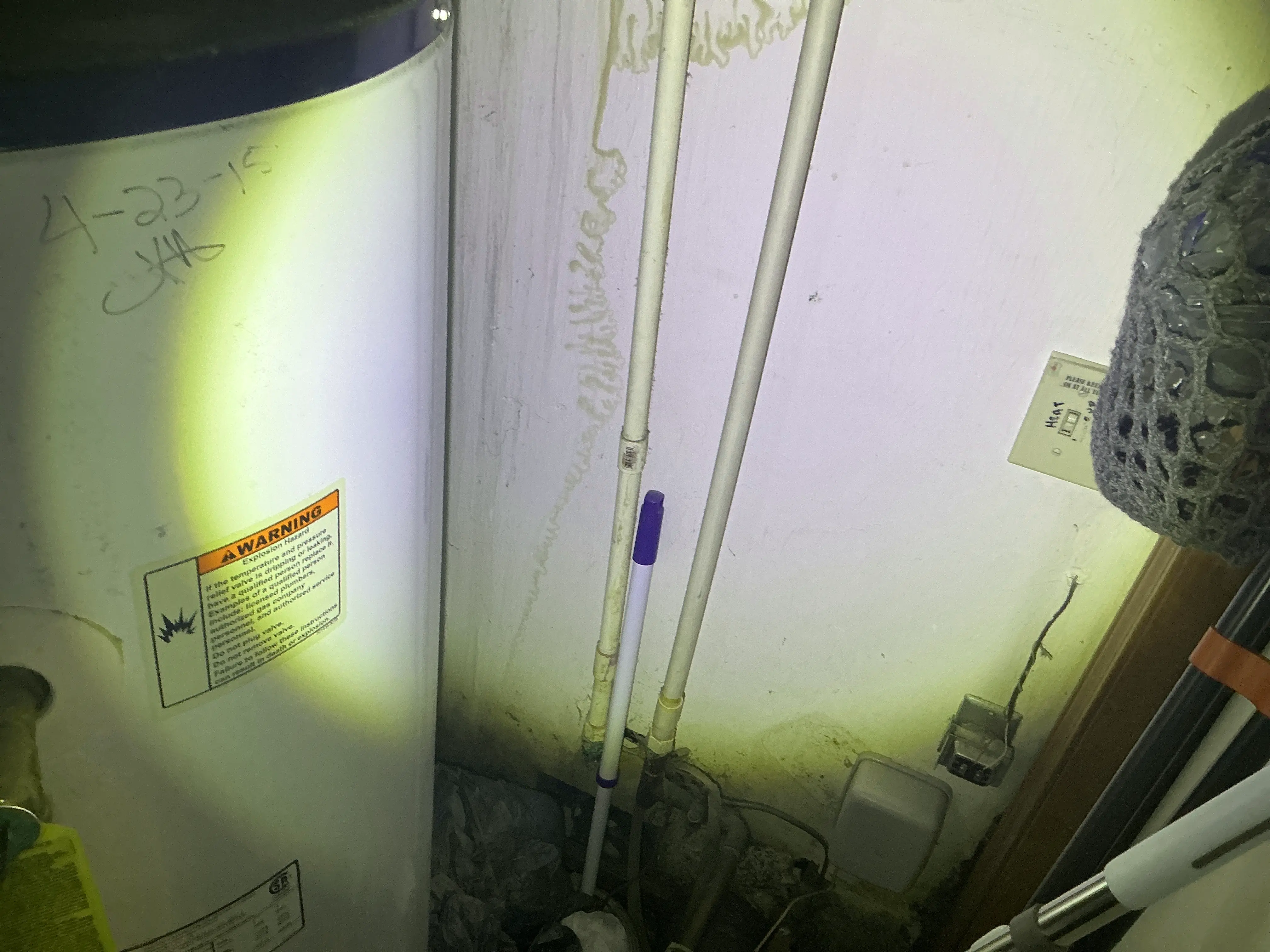 Water damage and staining on the drywall wall behind a water heater 2026-08-24