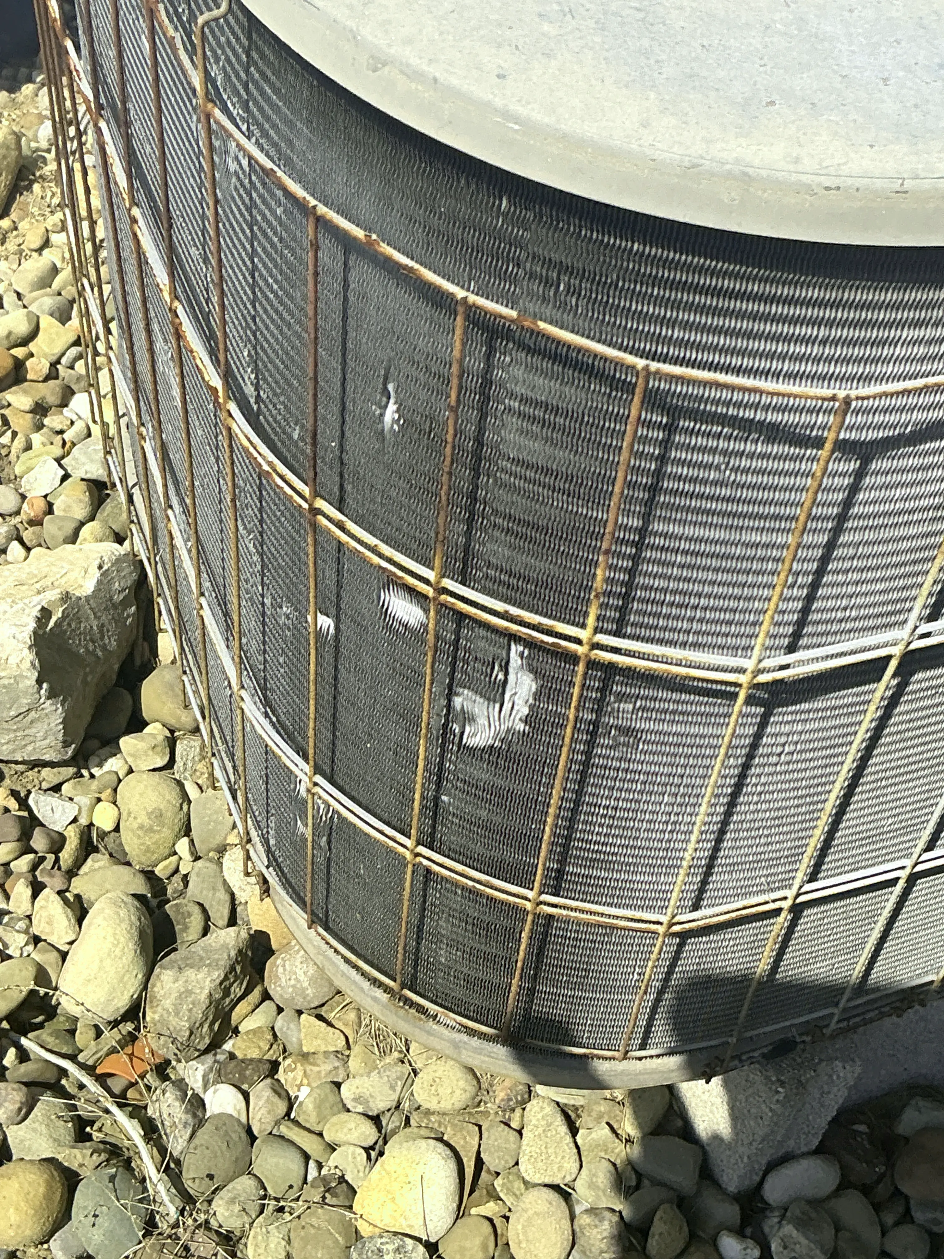 Damaged condenser fins and rusted cage on an outdoor air conditioning unit 2026-08-06